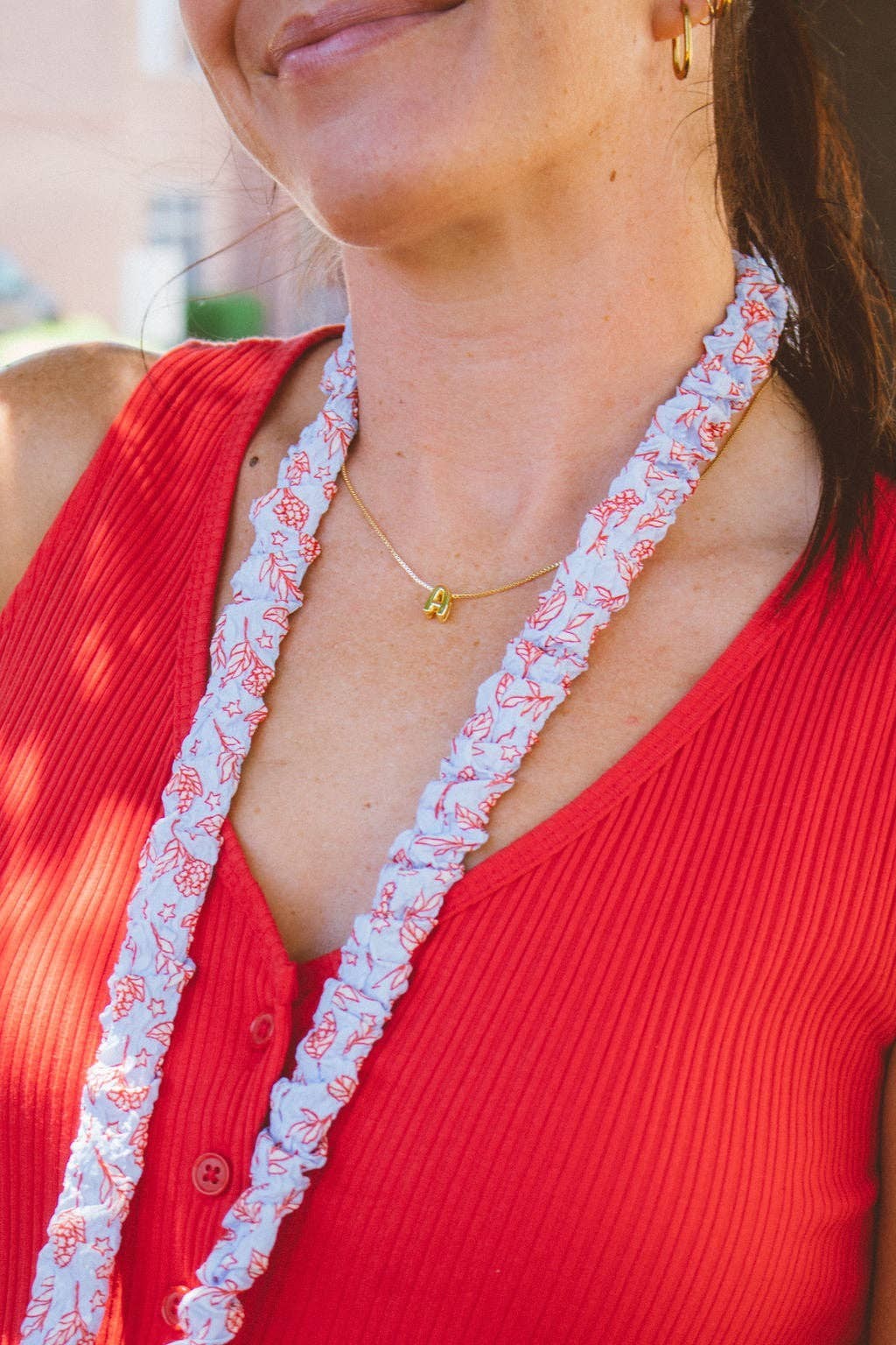 Doodlations Coffee Bar & Boutique hydrangea floral lanyard in red, white, and blue worn around a woman's neck.