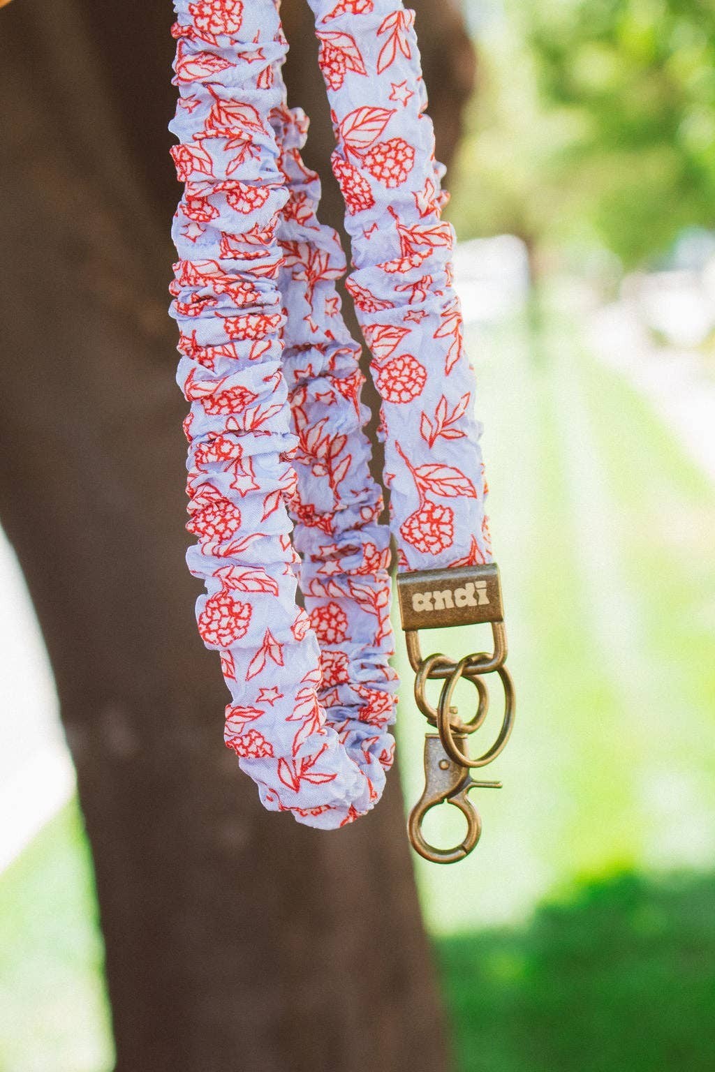 Doodlations Coffee Bar & Boutique hydrangea floral lanyard in red, white, and blue with antique brass hardware.