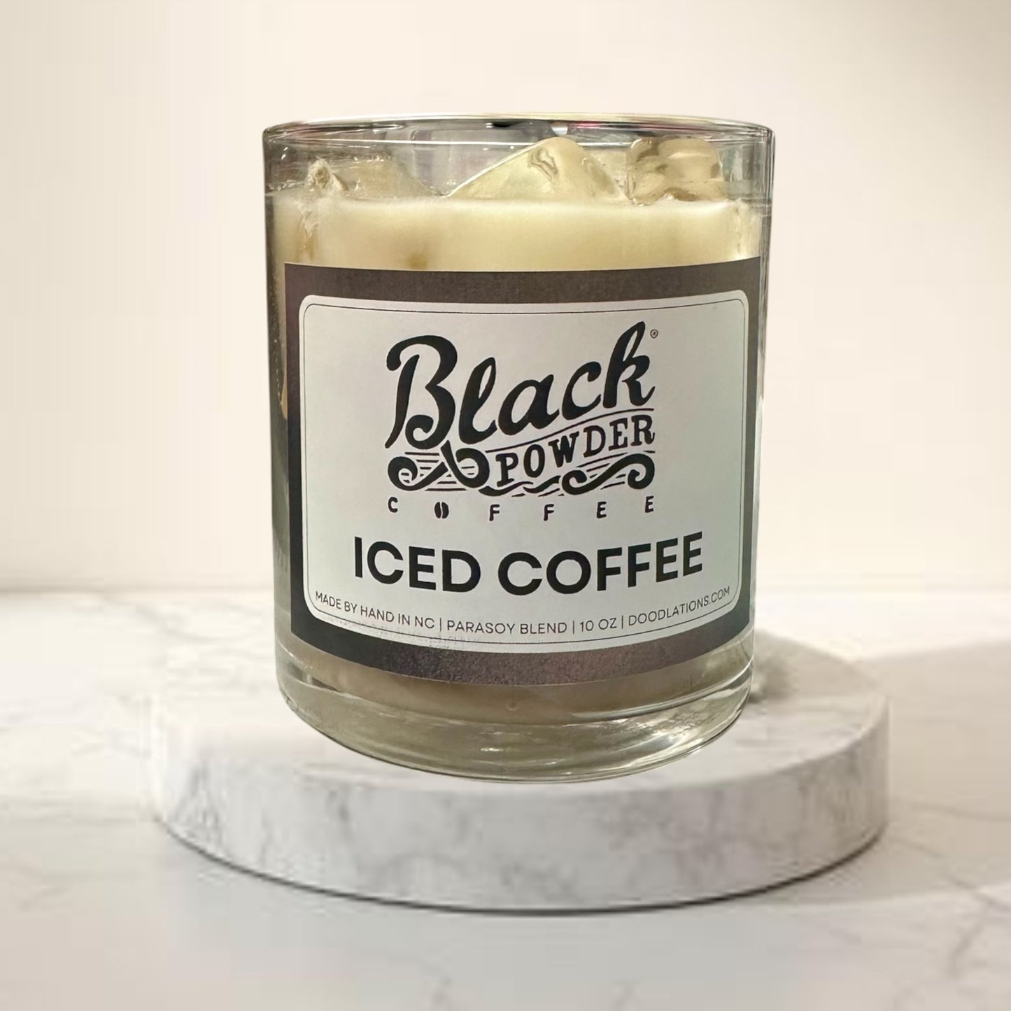 Doodlations Coffee Bar & Boutique Black Powder Iced Coffee candle in a glass jar with a soy blend wax and ice cube details.