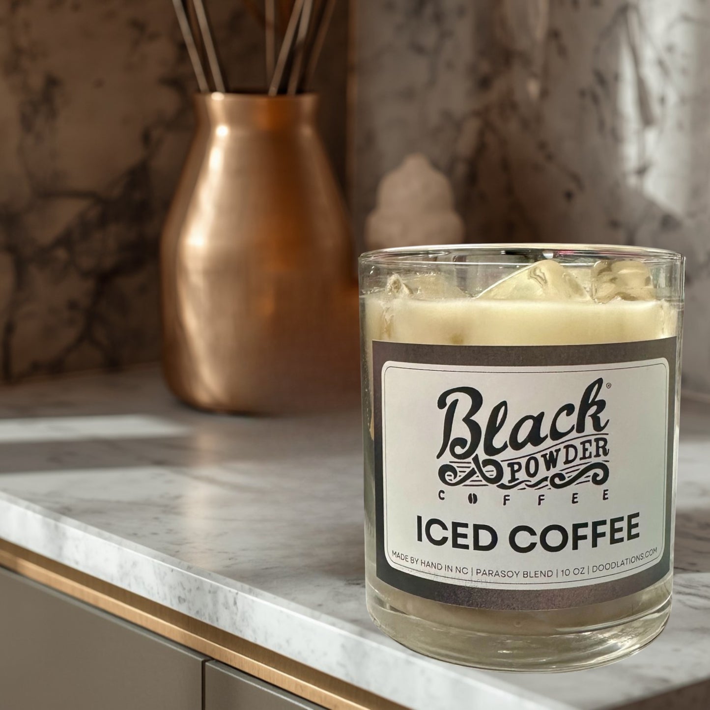 Doodlations Coffee Bar & Boutique Black Powder Iced Coffee candle in a glass jar with a parasoy blend wax and ice cube details.