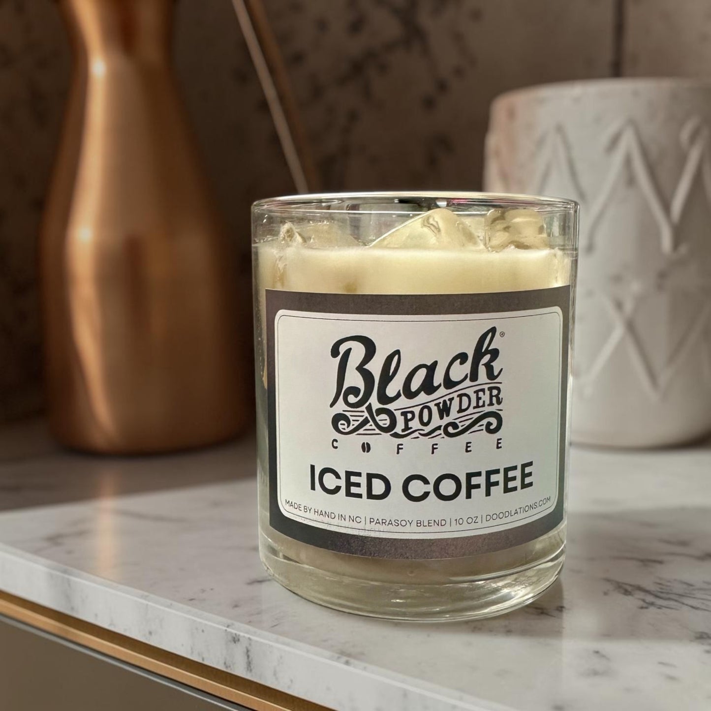Doodlations Coffee Bar & Boutique Black Powder Iced Coffee candle in a glass jar with a parasoy blend wax and ice cube details.