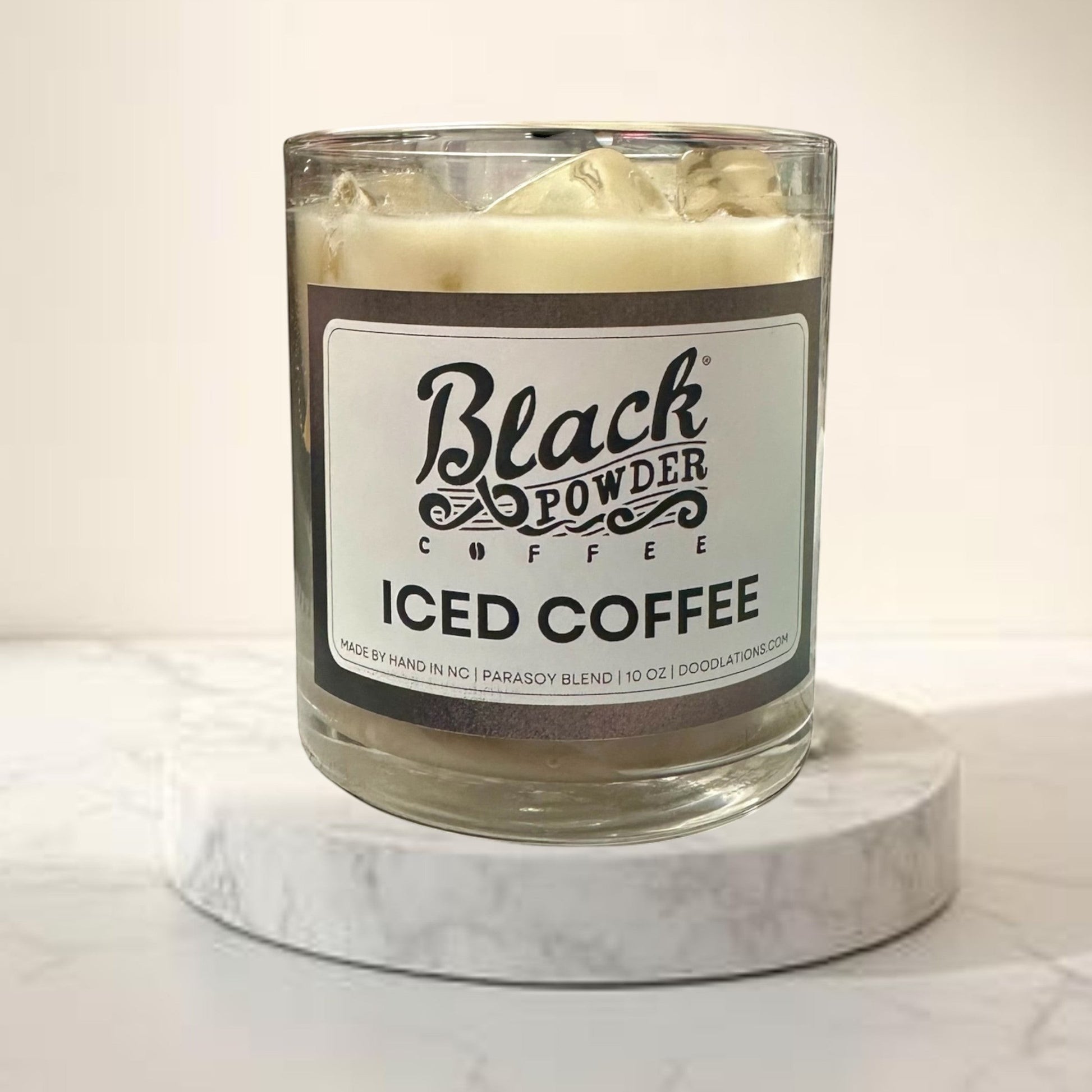 Doodlations Coffee Bar & Boutique Black Powder Iced Coffee candle in a glass jar with a soy blend wax and ice cube details.