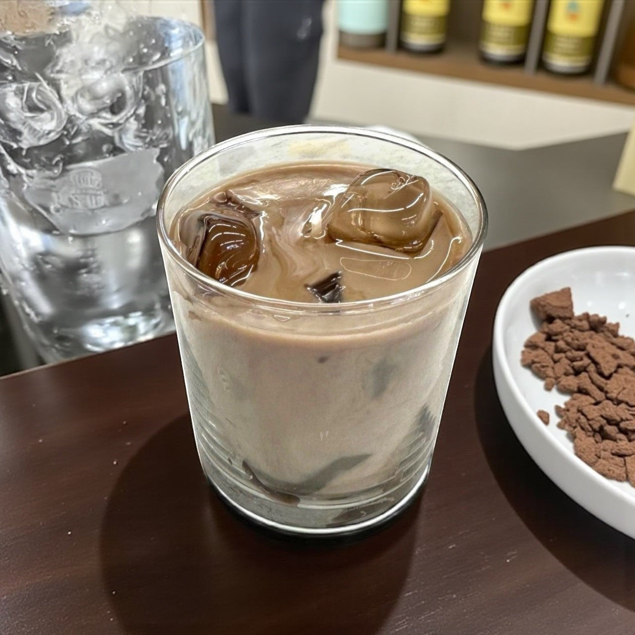 Doodlations Coffee Bar & Boutique iced hazelnut & cream coffee candle. Rich brown coffee-colored wax with ice cube-like embeds.