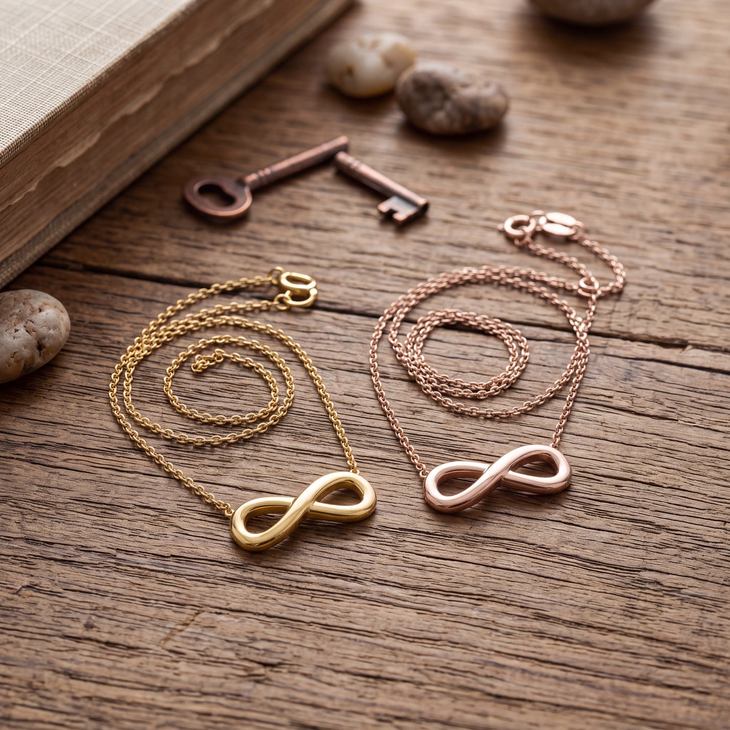 Doodlations Coffee Bar & Boutique gold and rose gold infinity symbol pendant necklaces on a rustic wooden table.