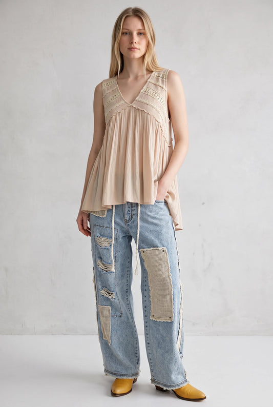 Model wearing a Doodlations Coffee Bar & Boutique ivory sleeveless V-neck tank top with lace trim and flowy fit.