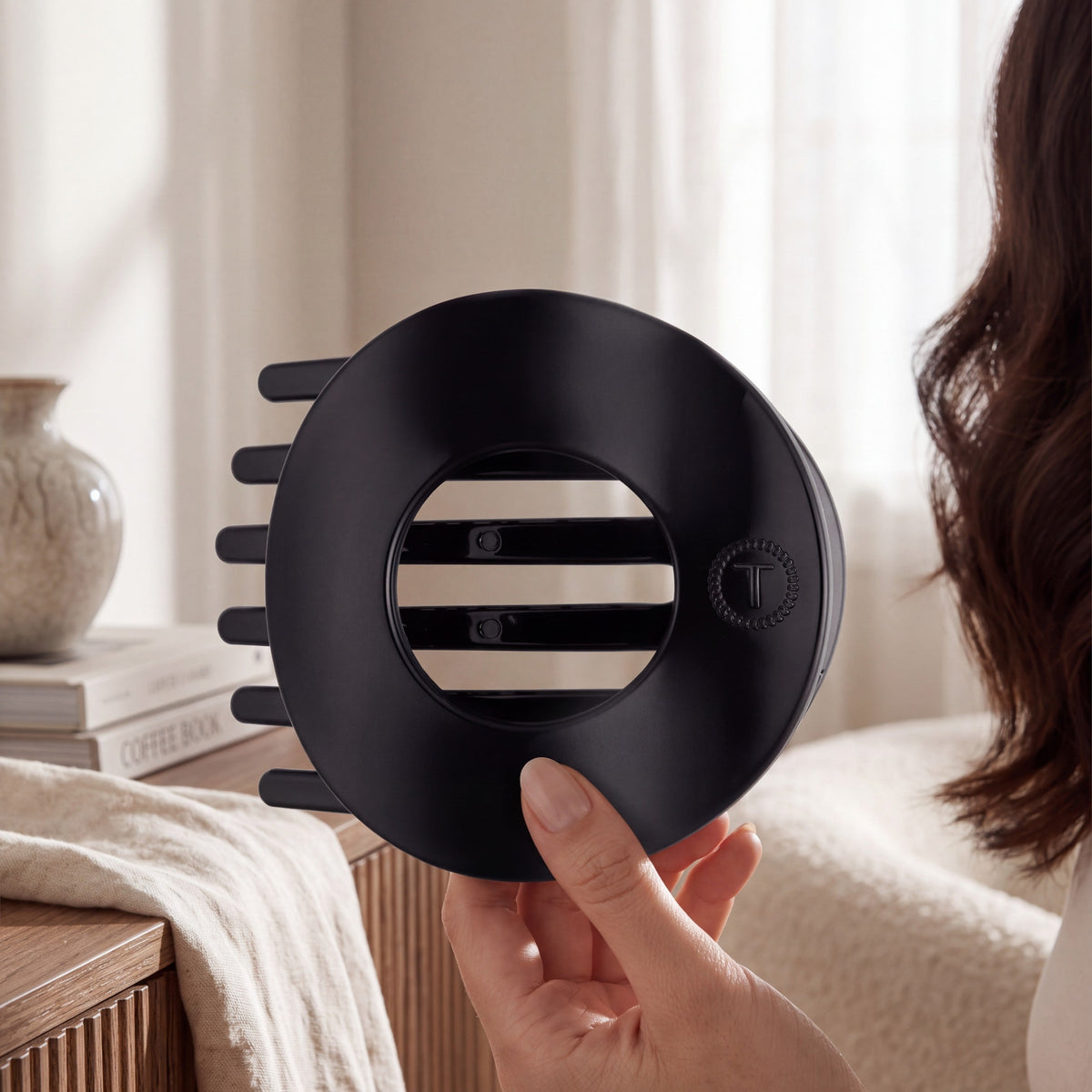 Doodlations Coffee Bar & Boutique Teleties jet black flat circle hair clip held in hand for a comfortable secure hold