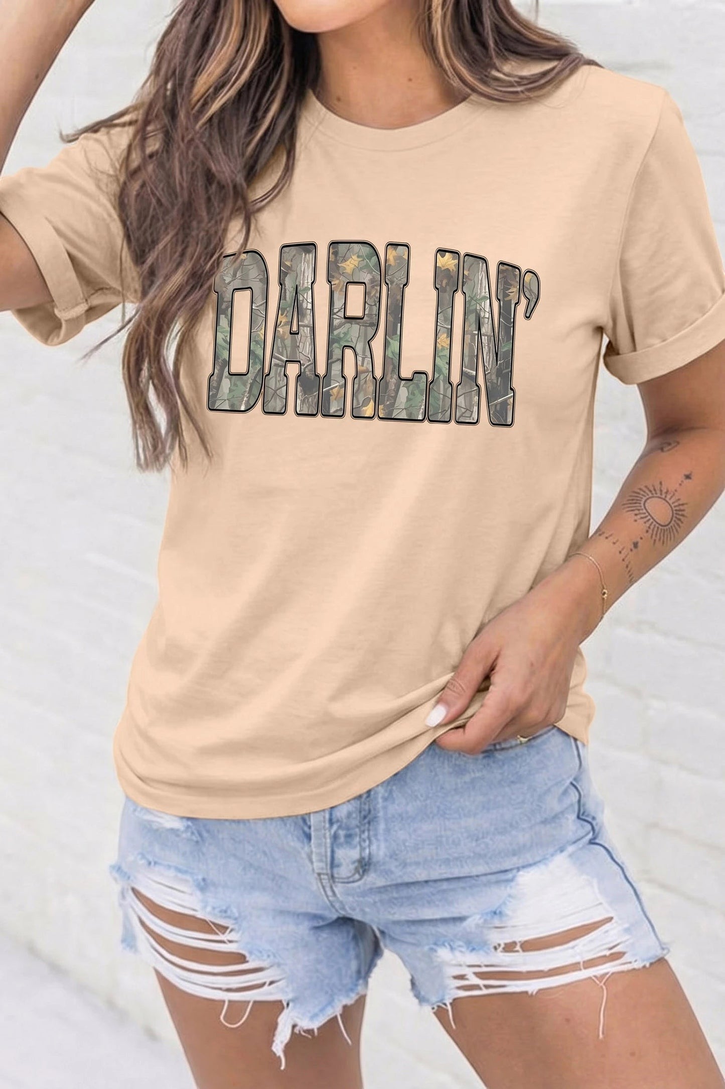 Doodlations Coffee Bar & Boutique khaki crewneck t-shirt featuring DARLIN in bold camo print worn by a woman