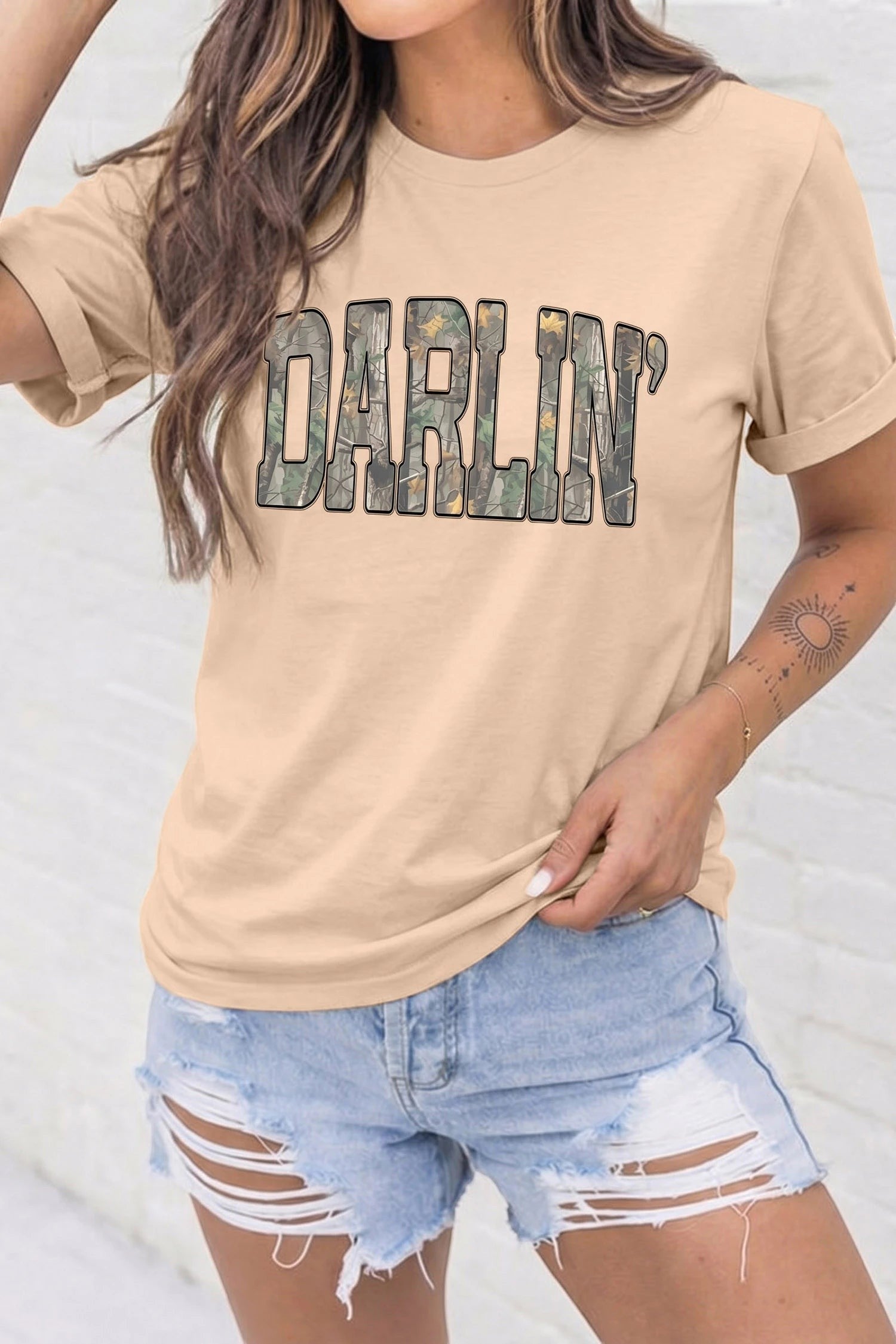 Doodlations Coffee Bar & Boutique khaki crewneck t-shirt featuring DARLIN in bold camo print worn by a woman