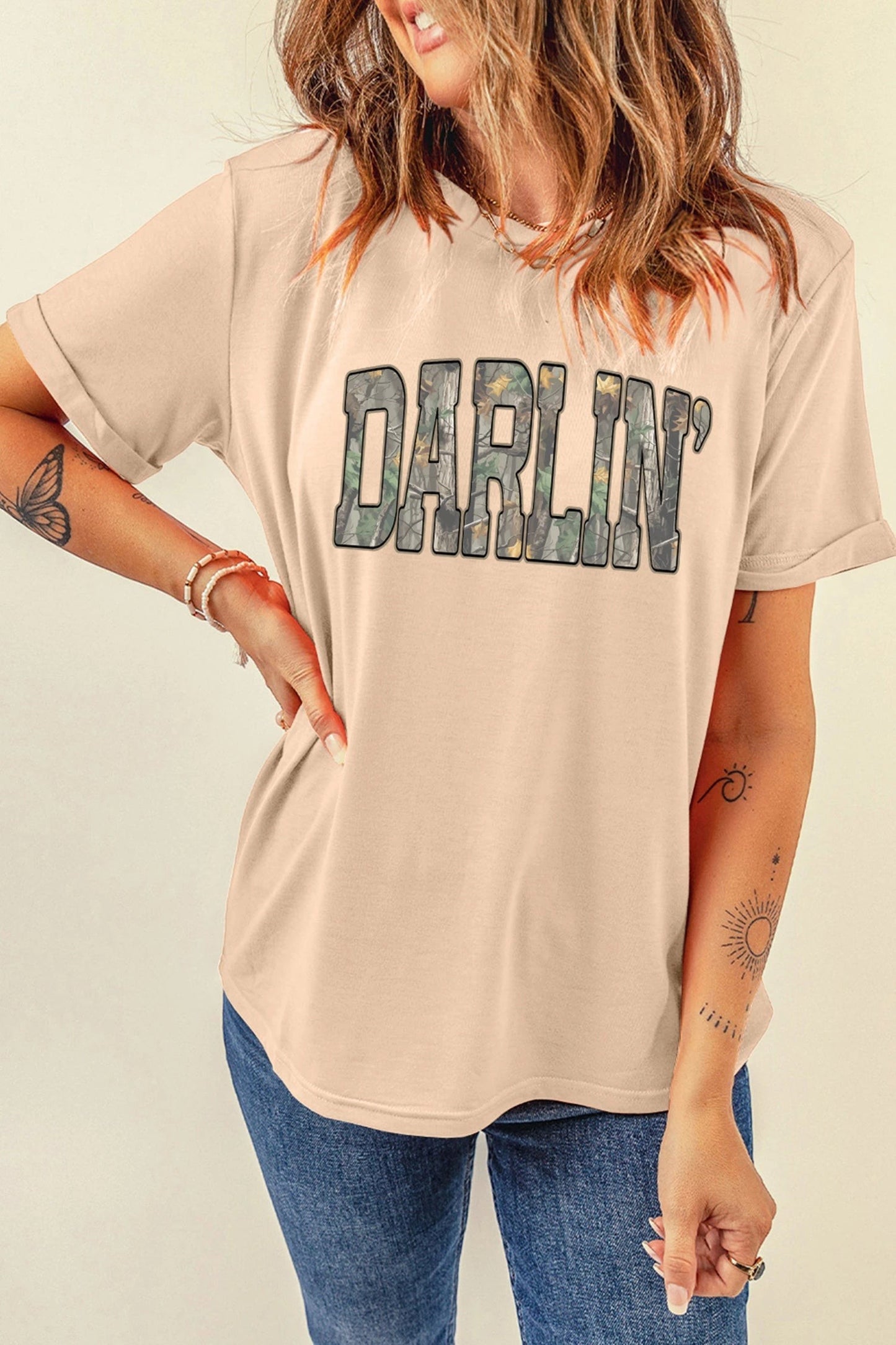Doodlations Coffee Bar & Boutique khaki crewneck t-shirt with DARLIN camo letter print worn by a woman