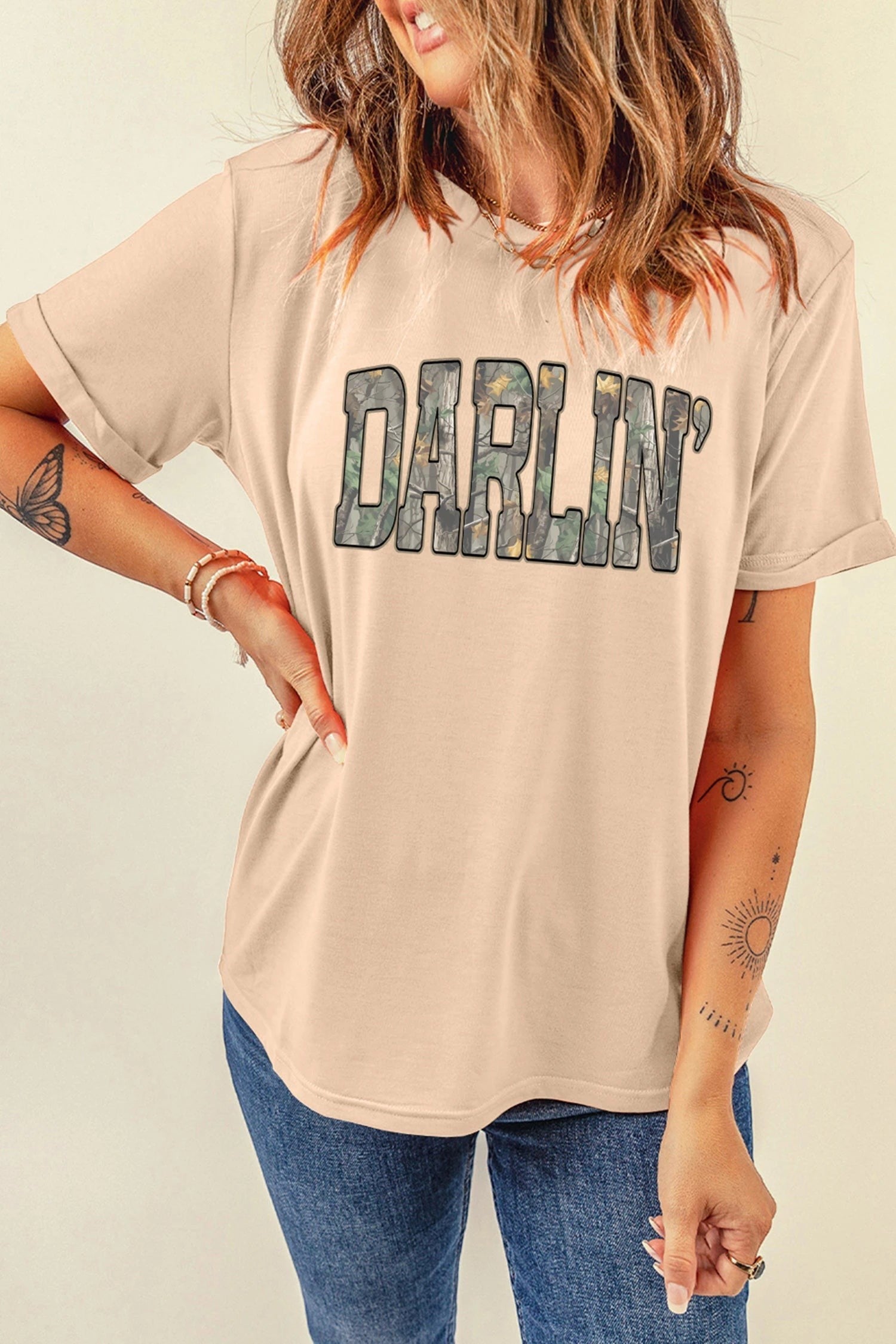 Doodlations Coffee Bar & Boutique khaki crewneck t-shirt with DARLIN camo letter print worn by a woman