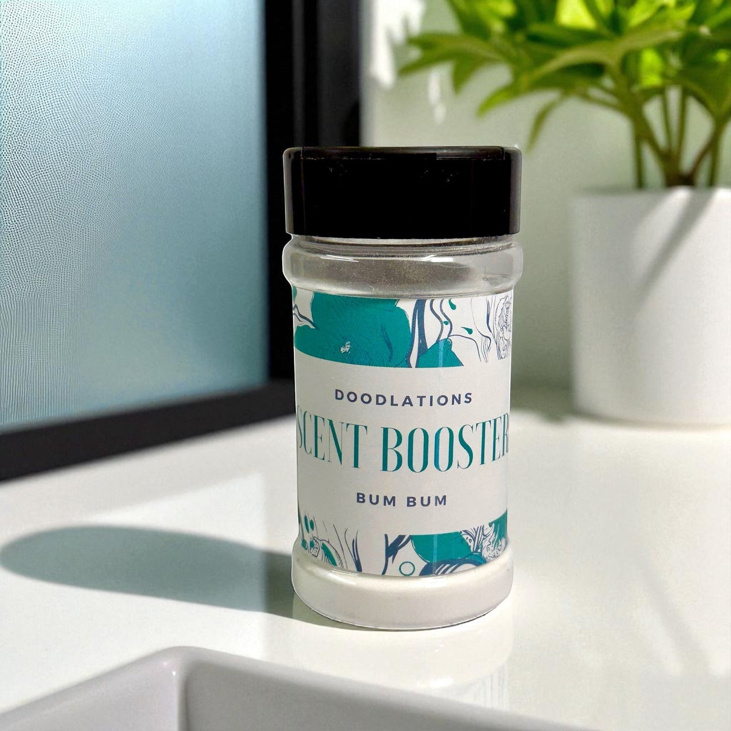 Doodlations Coffee Bar & Boutique Bum Bum laundry scent booster in a clear jar with a black lid. Tropical scent.