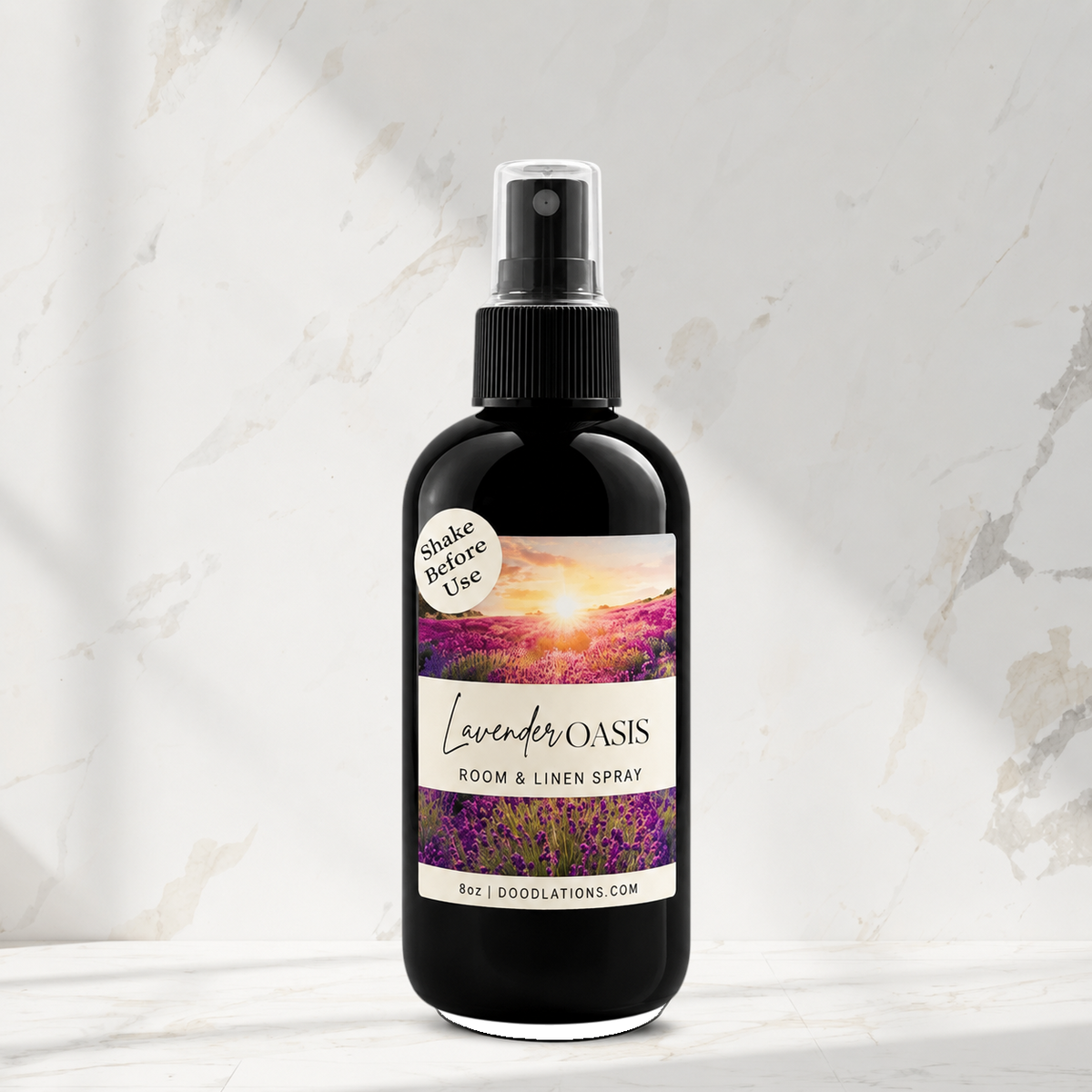 Doodlations Coffee Bar & Boutique Lavender Oasis room and linen spray in a black bottle on a marble surface.
