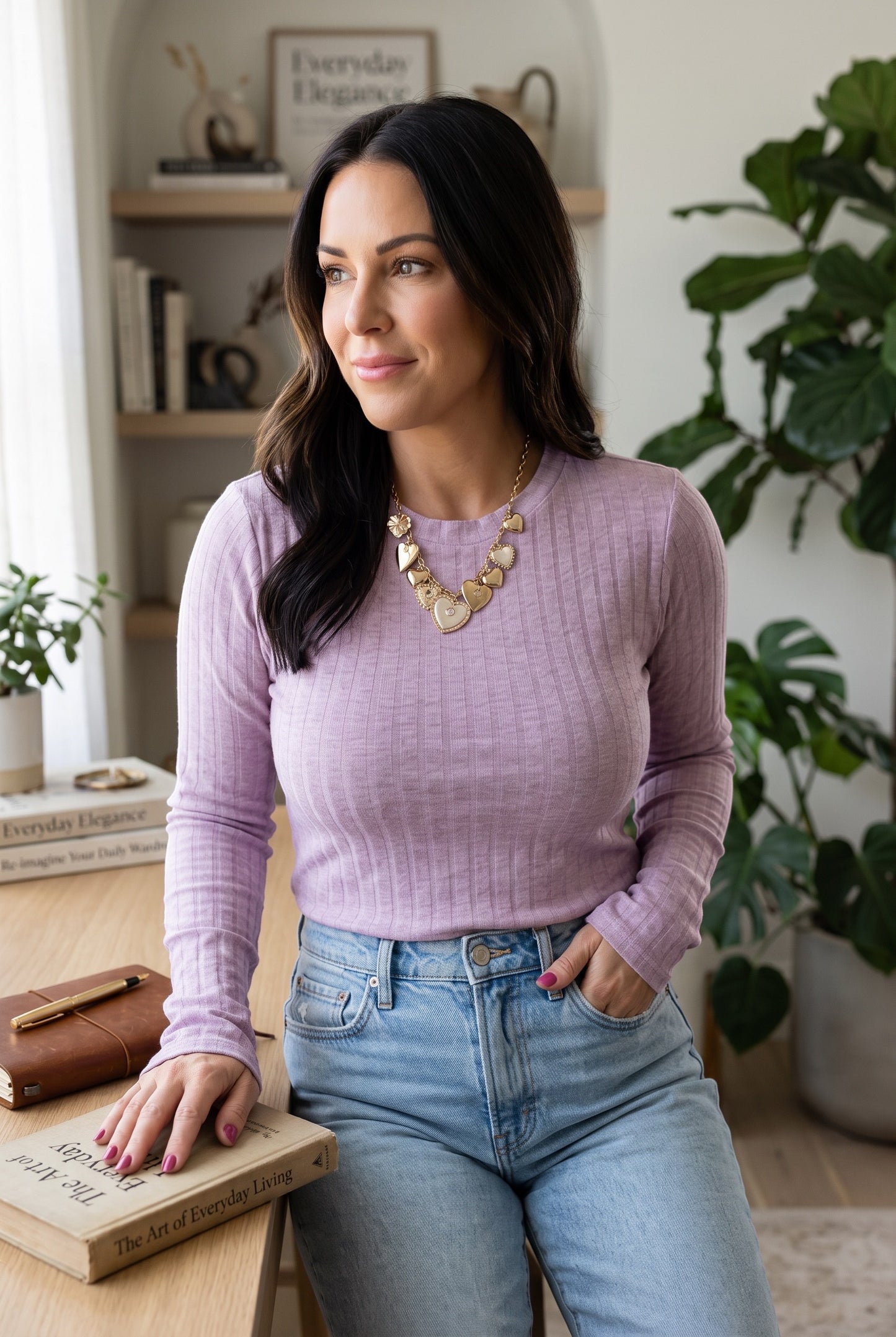 Woman wearing a Doodlations Coffee Bar & Boutique lavender ribbed long sleeve top with a gold heart necklace