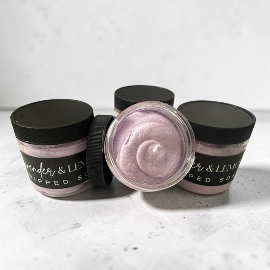 Doodlations Coffee Bar & Boutique Lavender Oasis whipped soap in small jars with black lids and creamy purple texture.