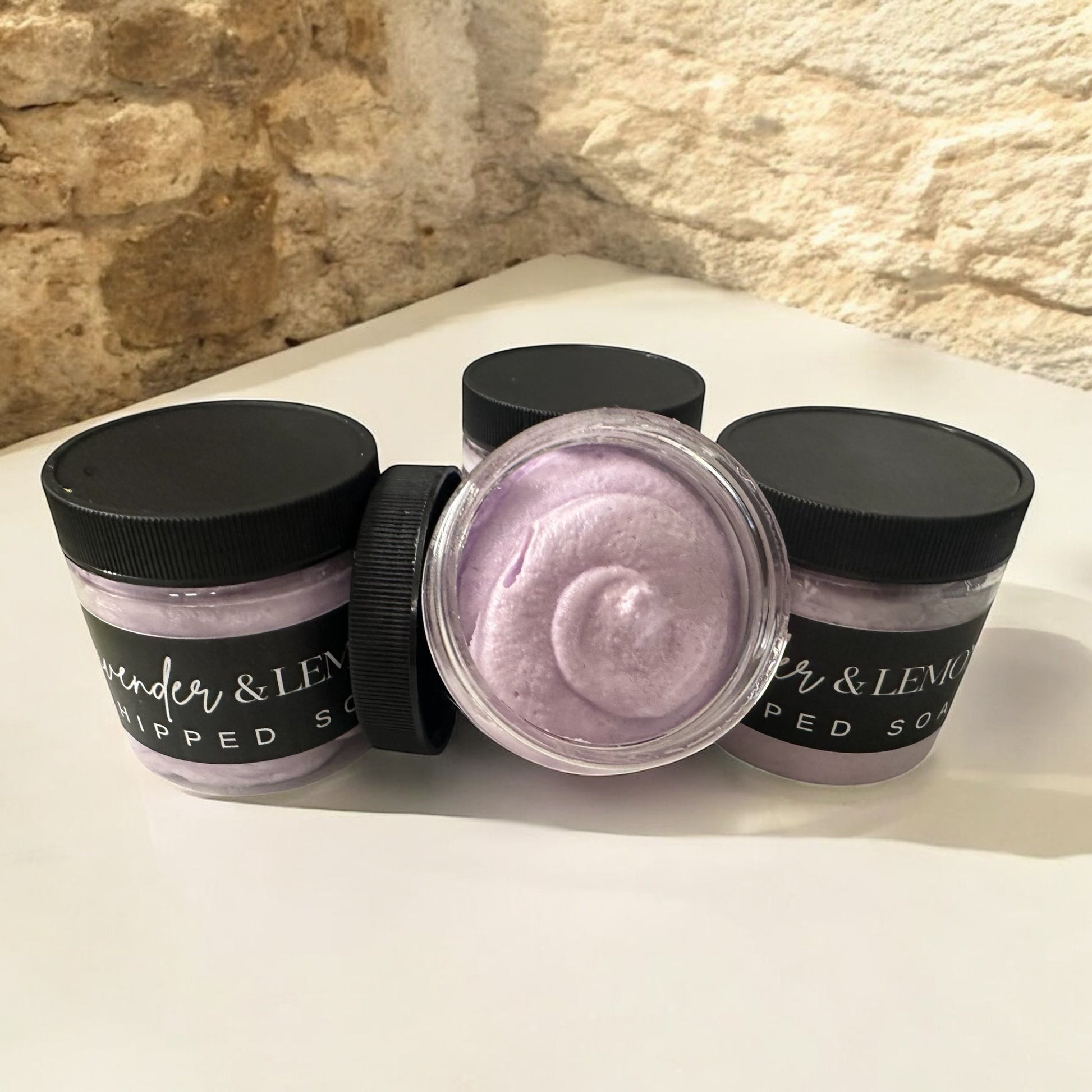 Doodlations Coffee Bar & Boutique Lavender Oasis whipped soap in clear jars with black lids on a white surface.