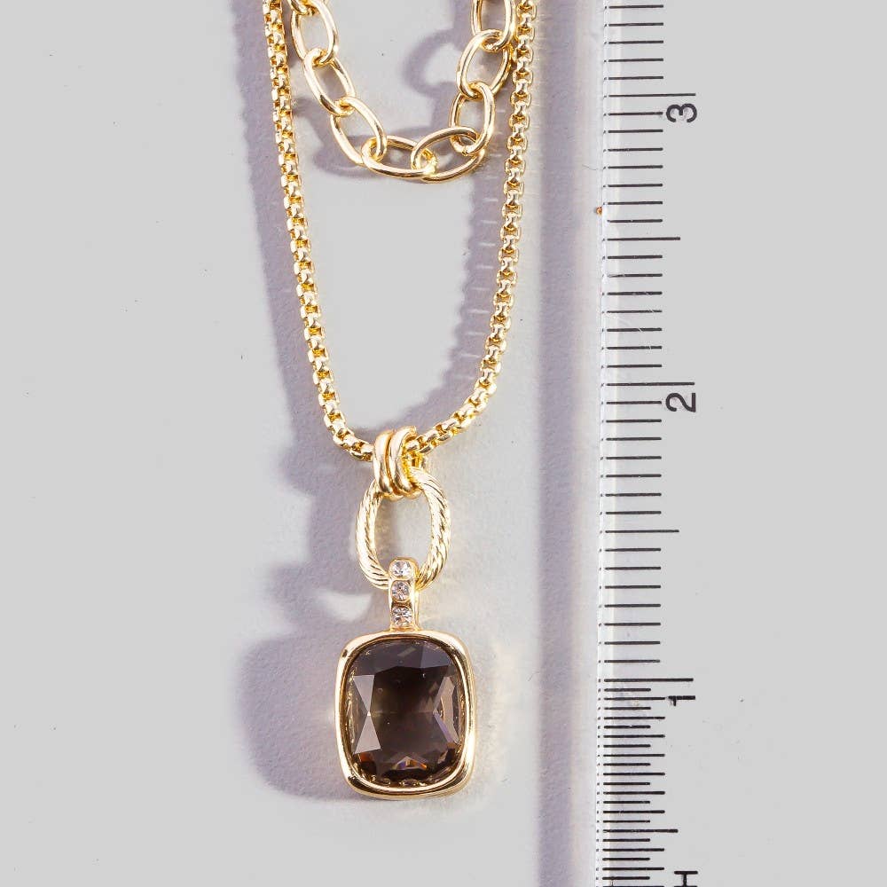 Doodlations Coffee Bar & Boutique layered gold-tone necklace with a smoky cushion-cut gemstone and crystal accents.