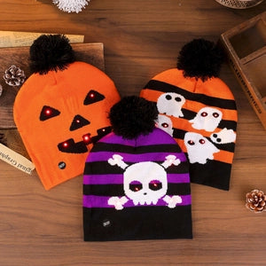 Doodlations Coffee Bar & Boutique LED knit beanies with pom-poms featuring pumpkin, ghost, and skull Halloween designs