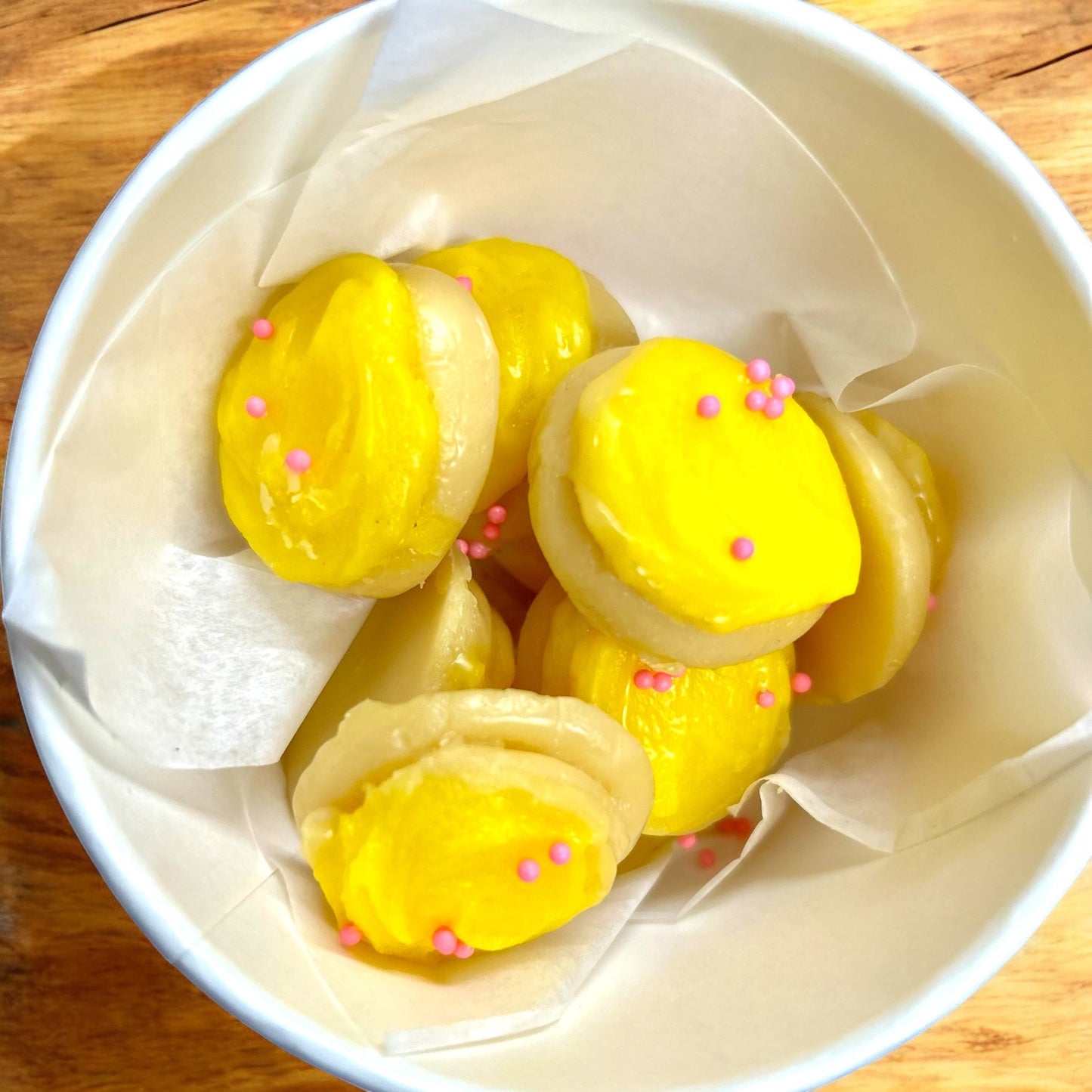 Doodlations Lemon Sugar Cookie wax melts, bright yellow with pink sprinkles, shaped like macarons.