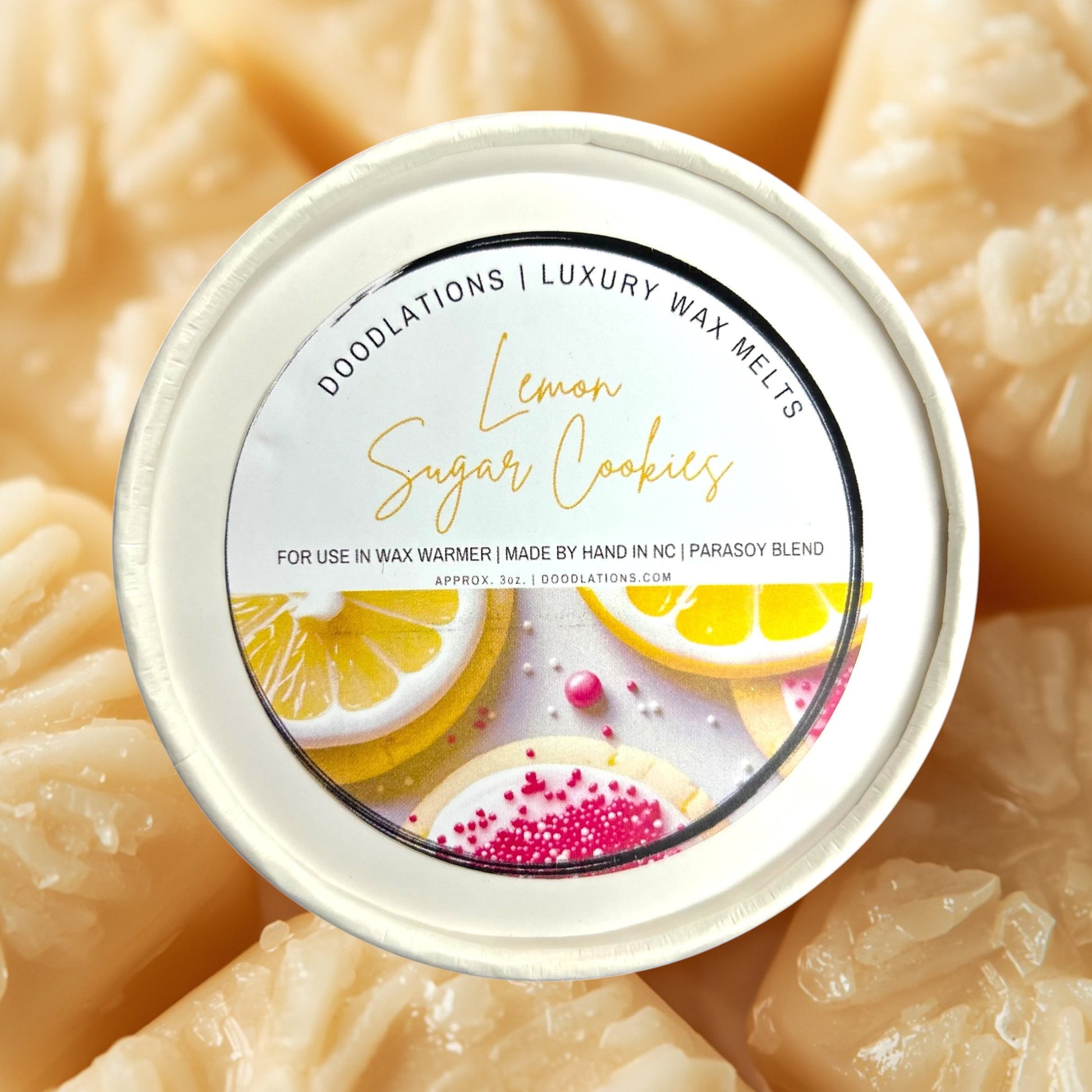 Doodlations Coffee Bar & Boutique Lemon Sugar Cookies luxury wax melts in a round container with lemon slices and decorated cookies.