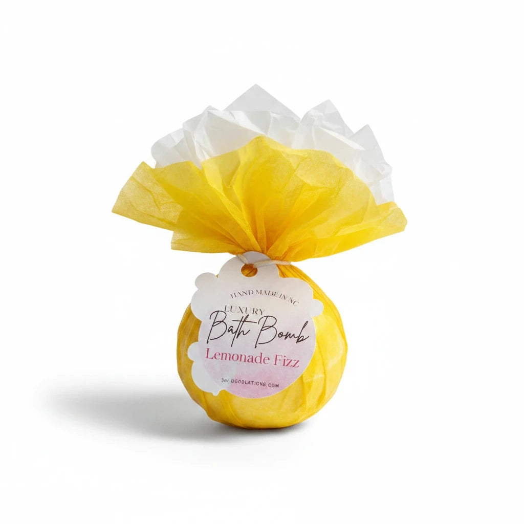 Doodlations Coffee Bar & Boutique Lemonade Fizz bath bomb wrapped in yellow tissue paper with a decorative tag