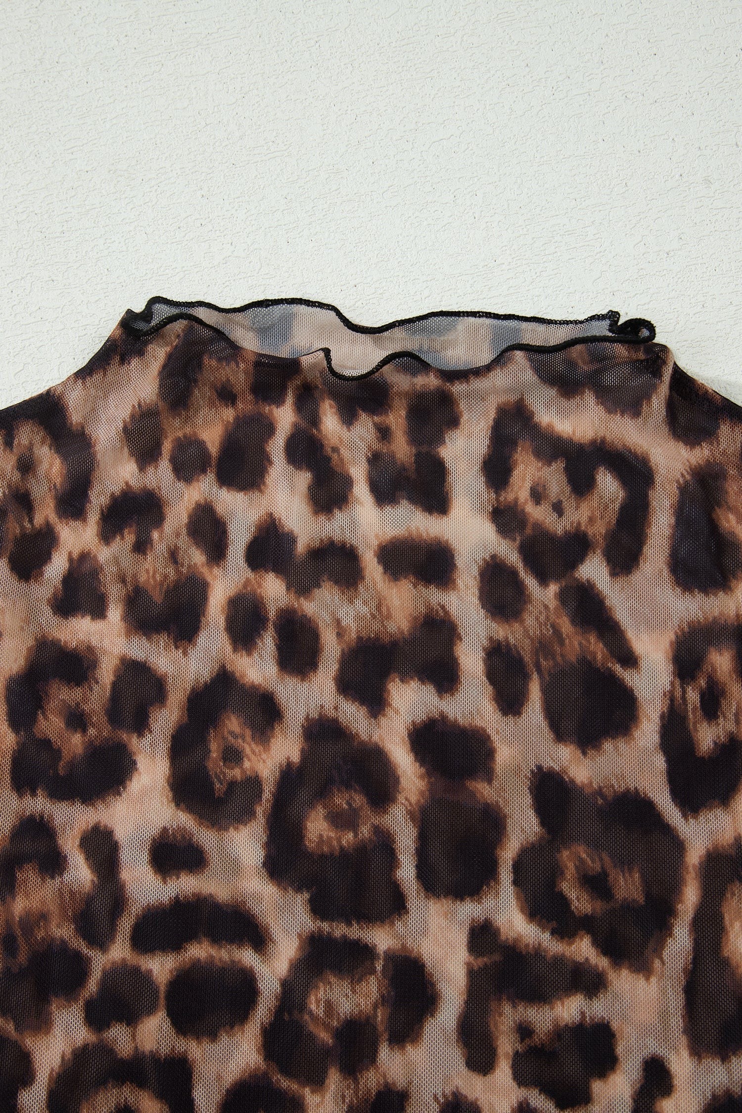 Doodlations Coffee Bar & Boutique leopard print mesh top with a delicate lettuce-edge neckline.