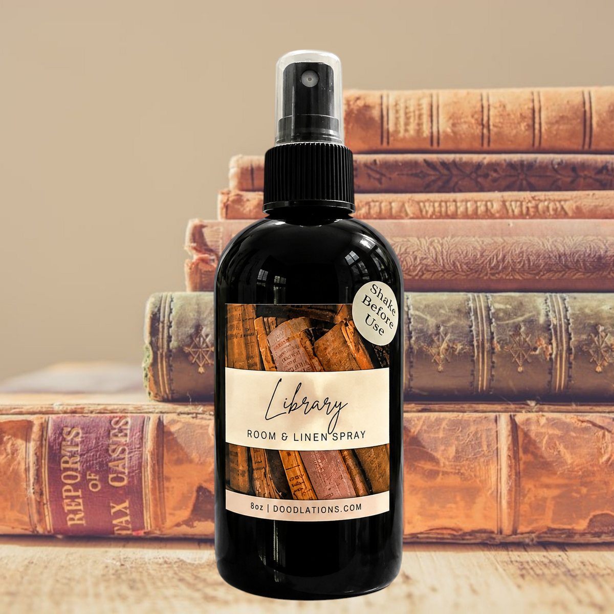 Doodlations Coffee Bar & Boutique Library room and linen spray in a black bottle against a stack of vintage books.