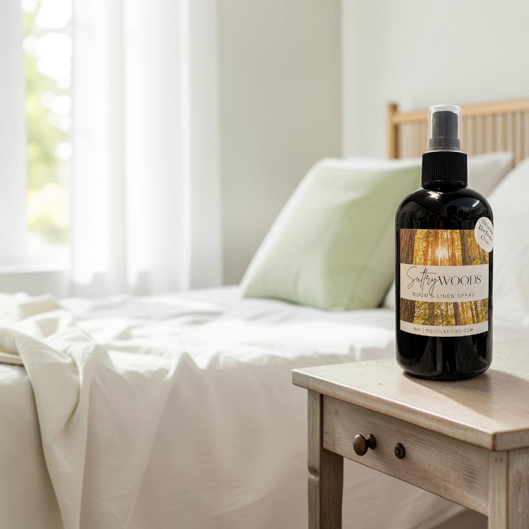 Doodlations Coffee Bar & Boutique 8oz room and linen spray in a black bottle with a forest-themed label
