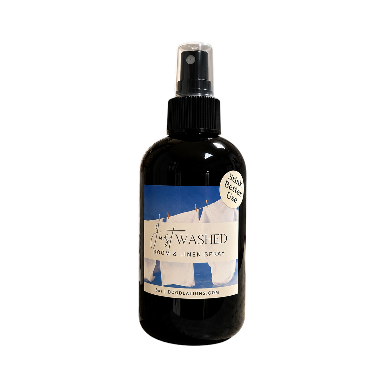 Doodlations Coffee Bar & Boutique Just Washed room and linen spray in an 8oz black bottle with a laundry-themed label.