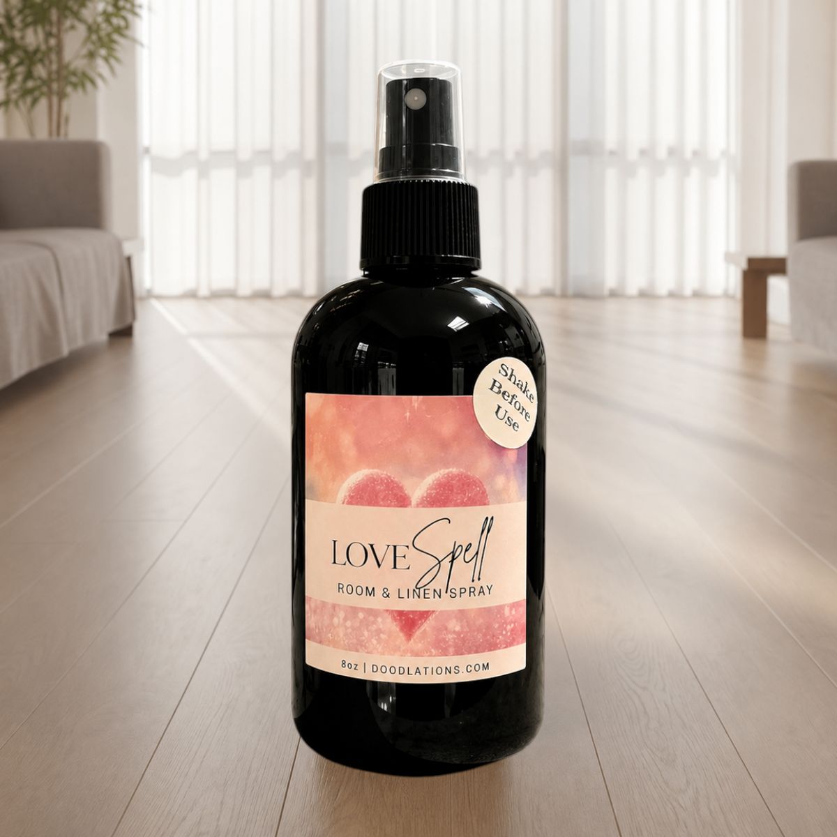 Doodlations Coffee Bar & Boutique Love Spell room and linen spray in a black bottle with a heart-themed label.