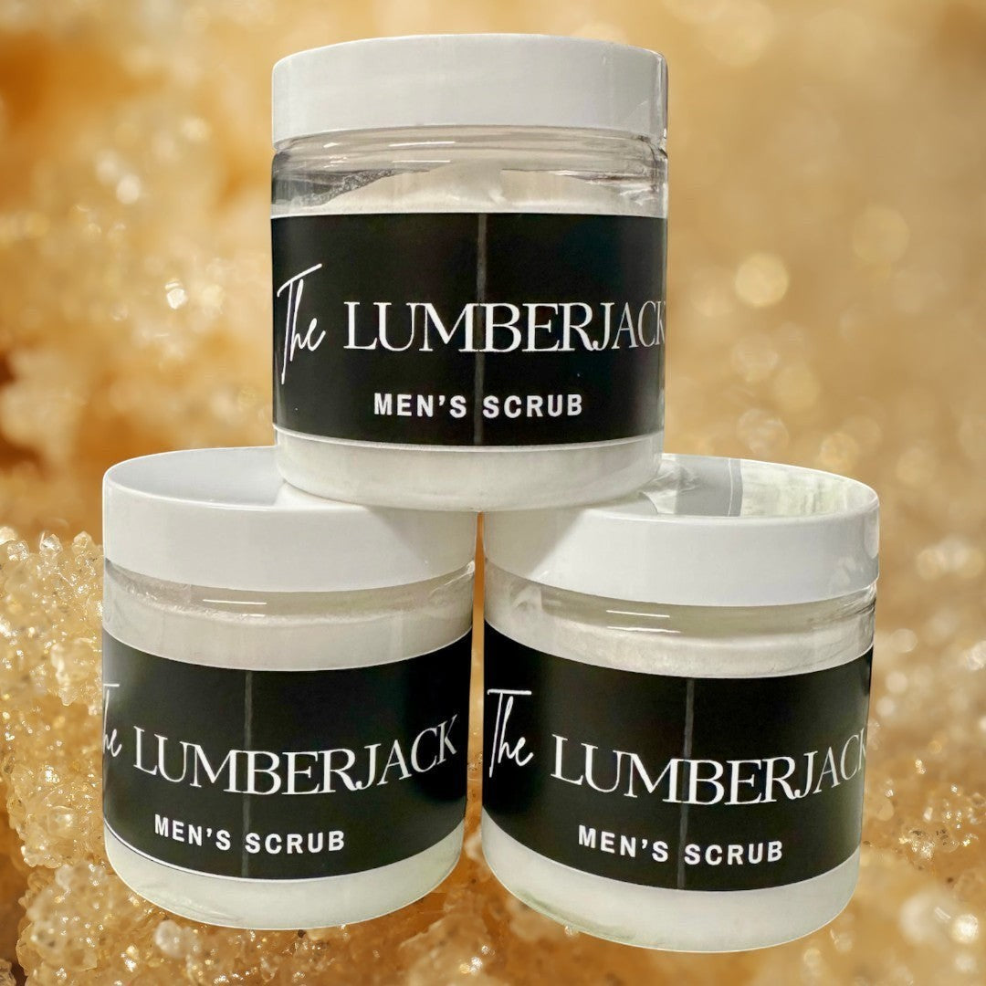 Doodlations Coffee Bar & Boutique The Lumberjack Men's Scrub in clear jars with black labels. Creamy white scrub inside.