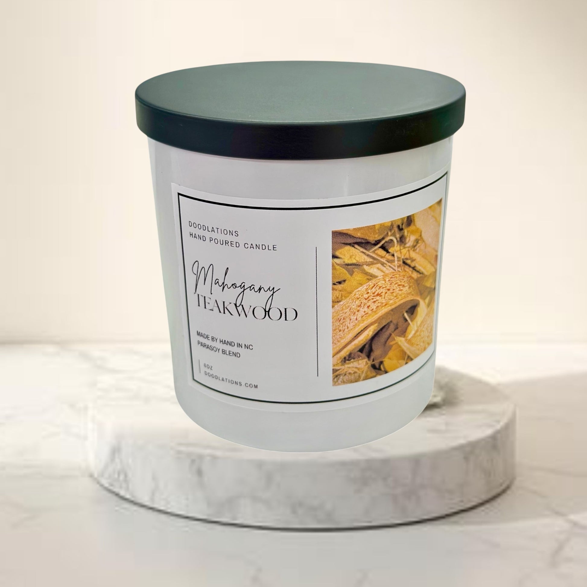 Doodlations Coffee Bar & Boutique Mahogany Teakwood hand-poured 8oz soy wax candle with a black lid.
