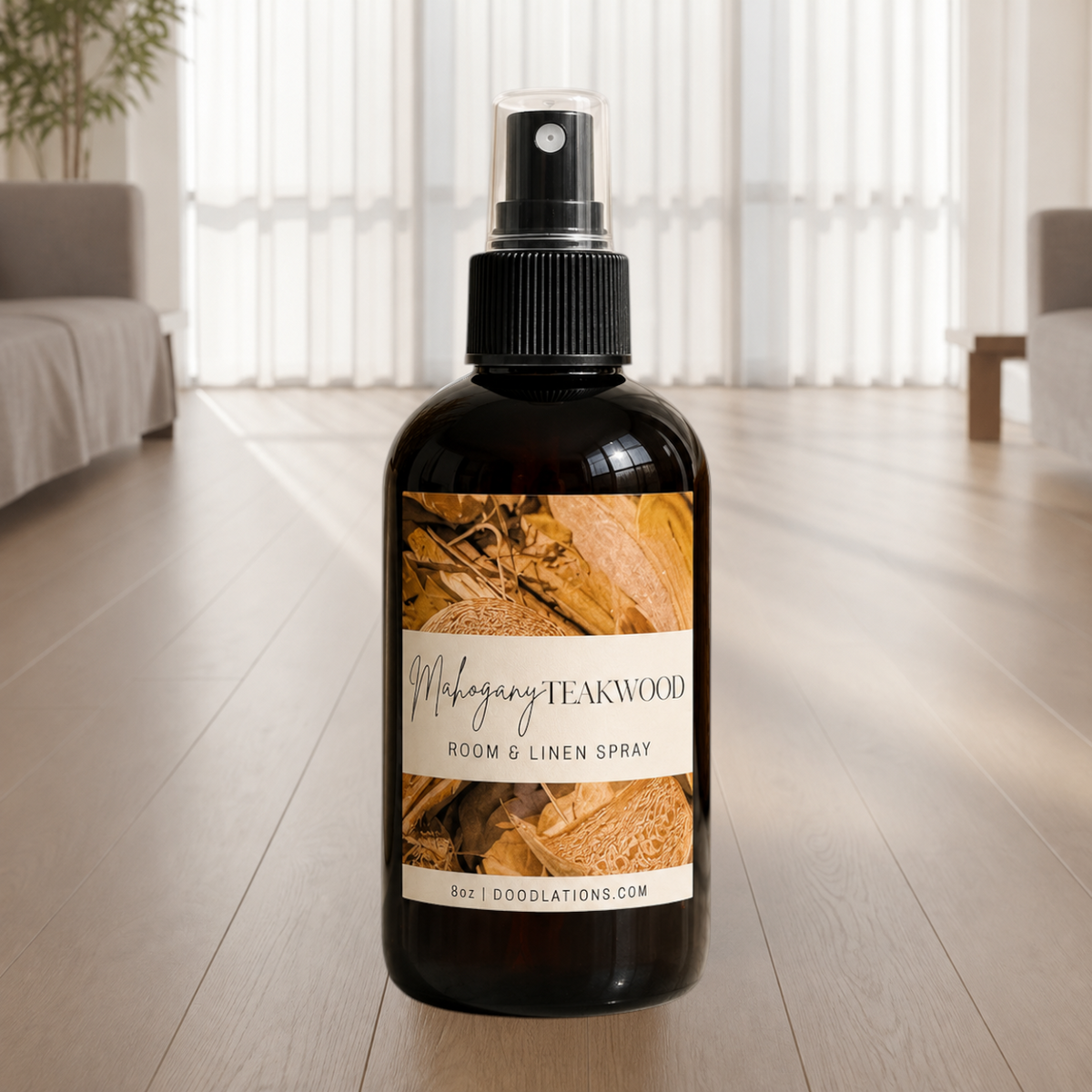 Doodlations Coffee Bar & Boutique Mahogany Teakwood room and linen spray in an amber glass bottle on a wooden floor.