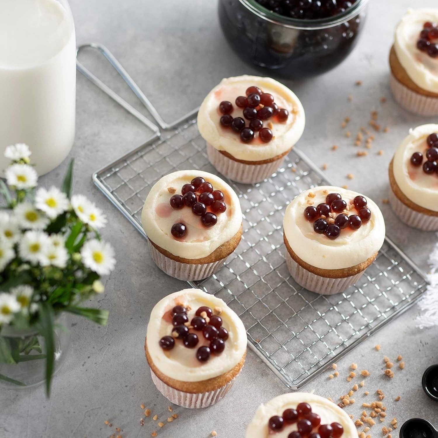 Doodlations Coffee Bar & Boutique mango bursting balls topping cupcakes with white frosting and a glass of milk.
