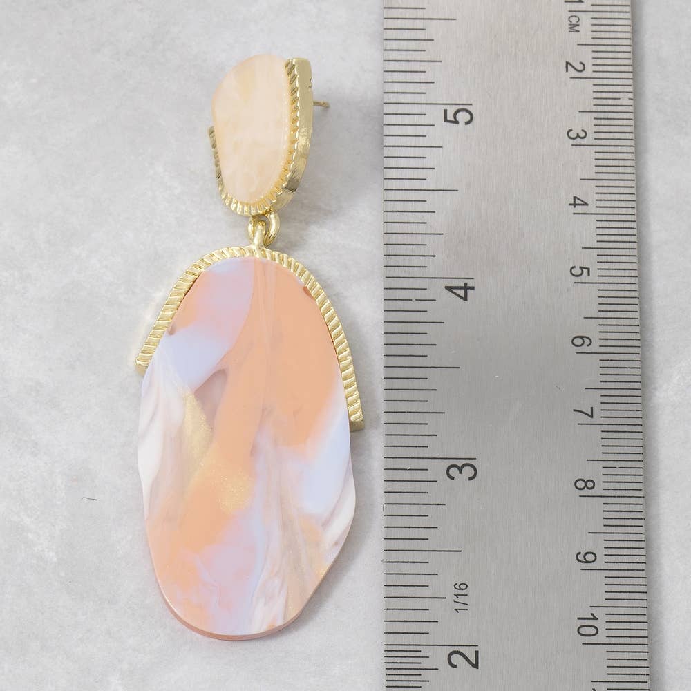 Doodlations Coffee Bar & Boutique marble resin teardrop earrings with gold-tone accents next to a metal ruler