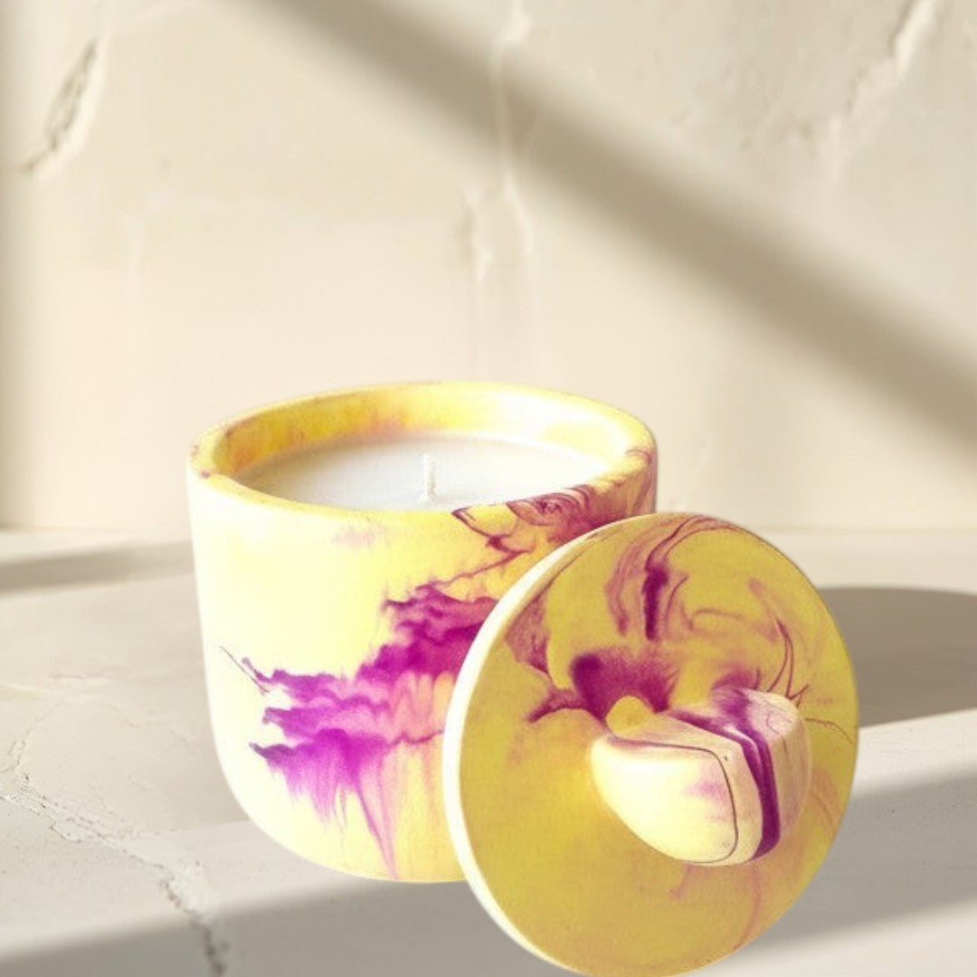 Doodlations Coffee Bar & Boutique yellow and violet marbled concrete candle with lid, hand-poured soy blend wax.