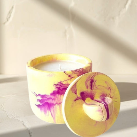 Doodlations Coffee Bar & Boutique yellow and violet marbled concrete candle with lid, hand-poured soy blend wax.