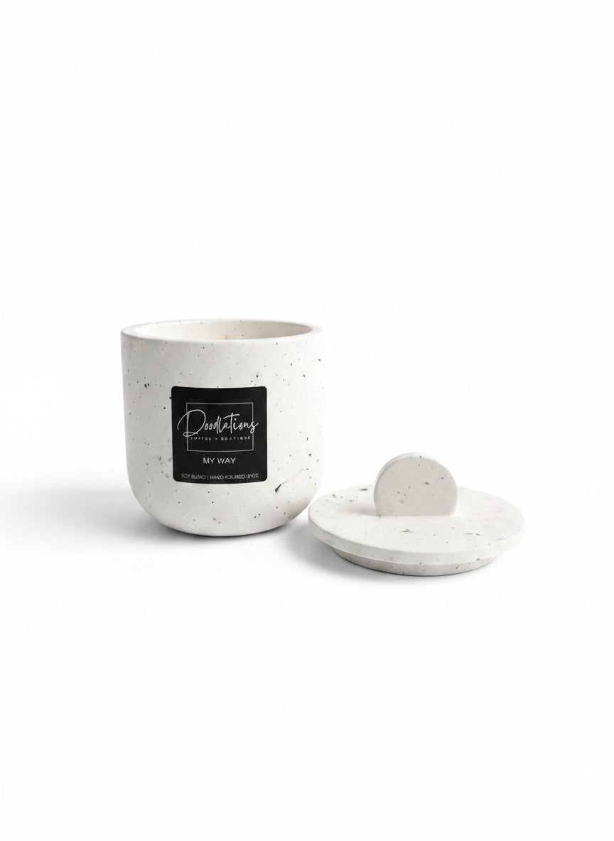 Doodlations Coffee Bar & Boutique marbled concrete candle with lid and black logo label on a white background