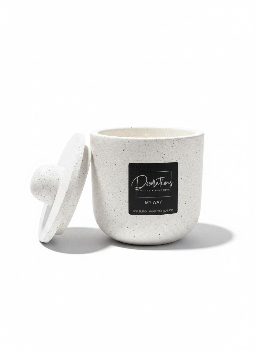 Doodlations Coffee Bar & Boutique My Way marbled concrete candle with lid in a speckled white finish.