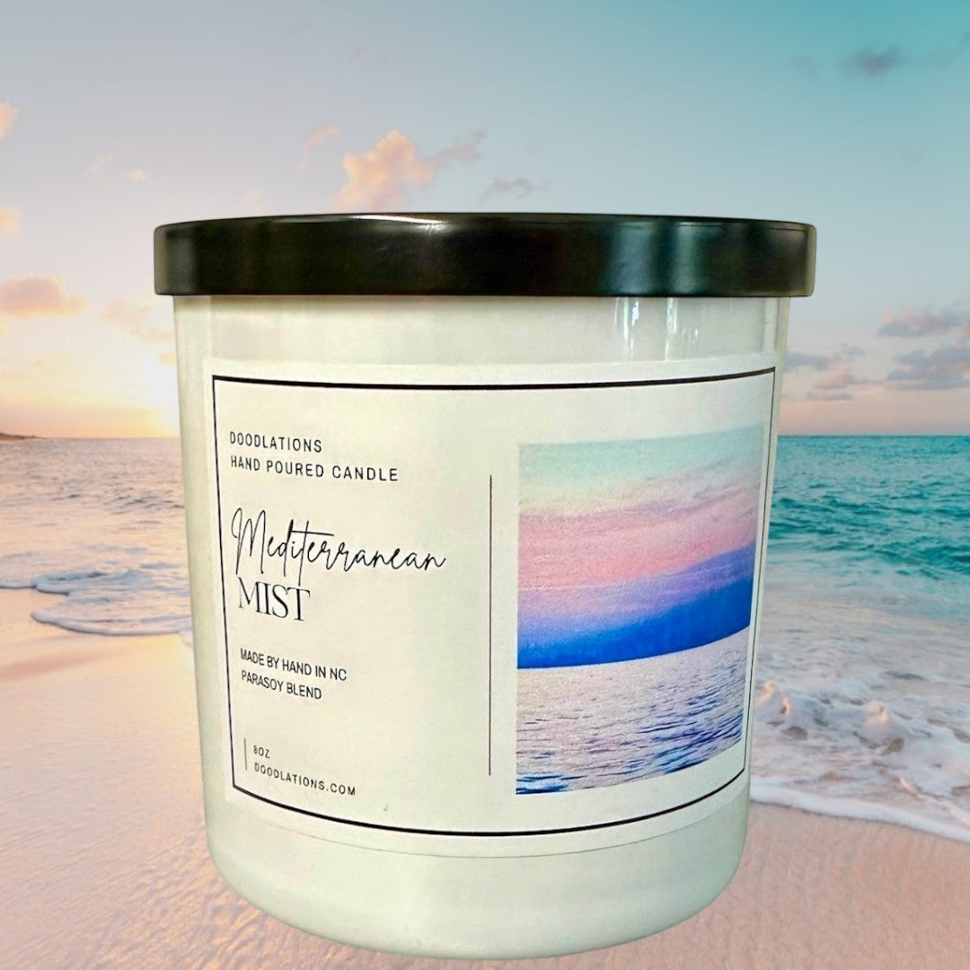 Doodlations Coffee Bar & Boutique Mediterranean Mist hand-poured soy blend candle with a coastal sunset image.