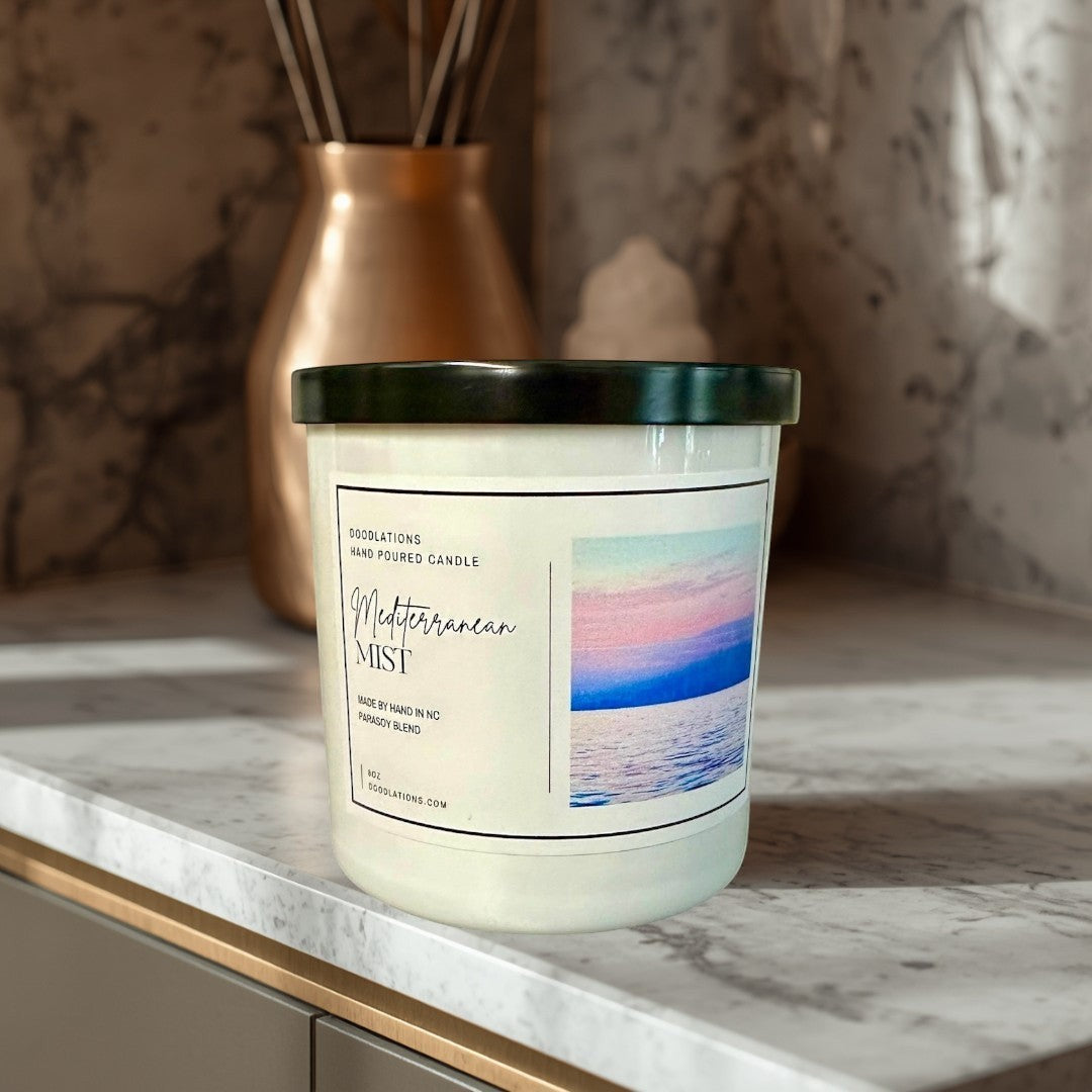 Doodlations Coffee Bar & Boutique Mediterranean Mist hand-poured soy blend candle with a coastal sunset image on the label.