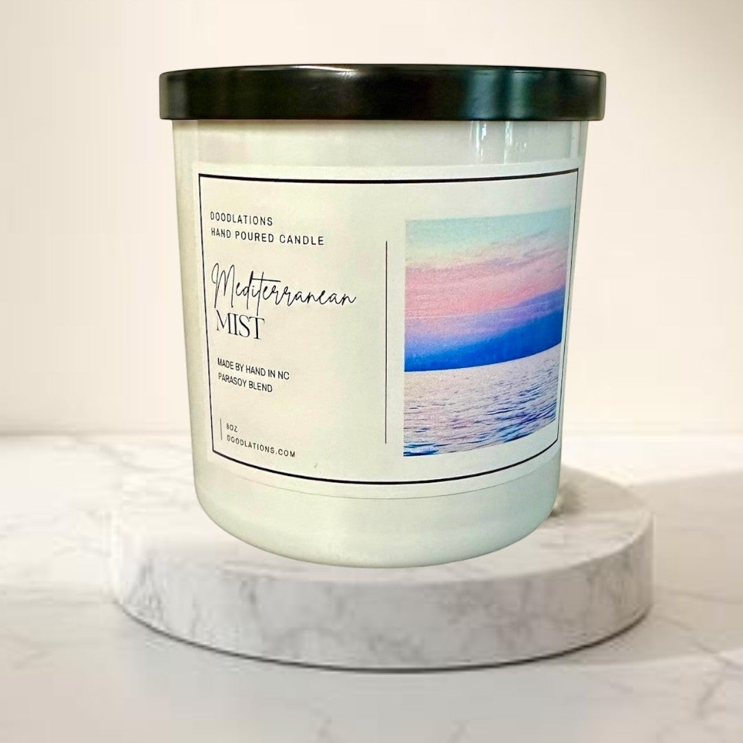 Doodlations Coffee Bar & Boutique Mediterranean Mist hand-poured soy blend candle with a coastal sunset image on the label.