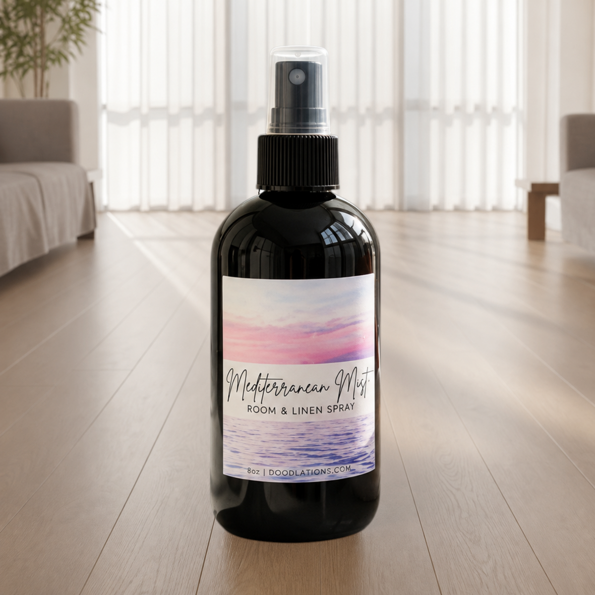 Doodlations Coffee Bar & Boutique Mediterranean Mist room and linen spray in a black bottle on a wooden floor.