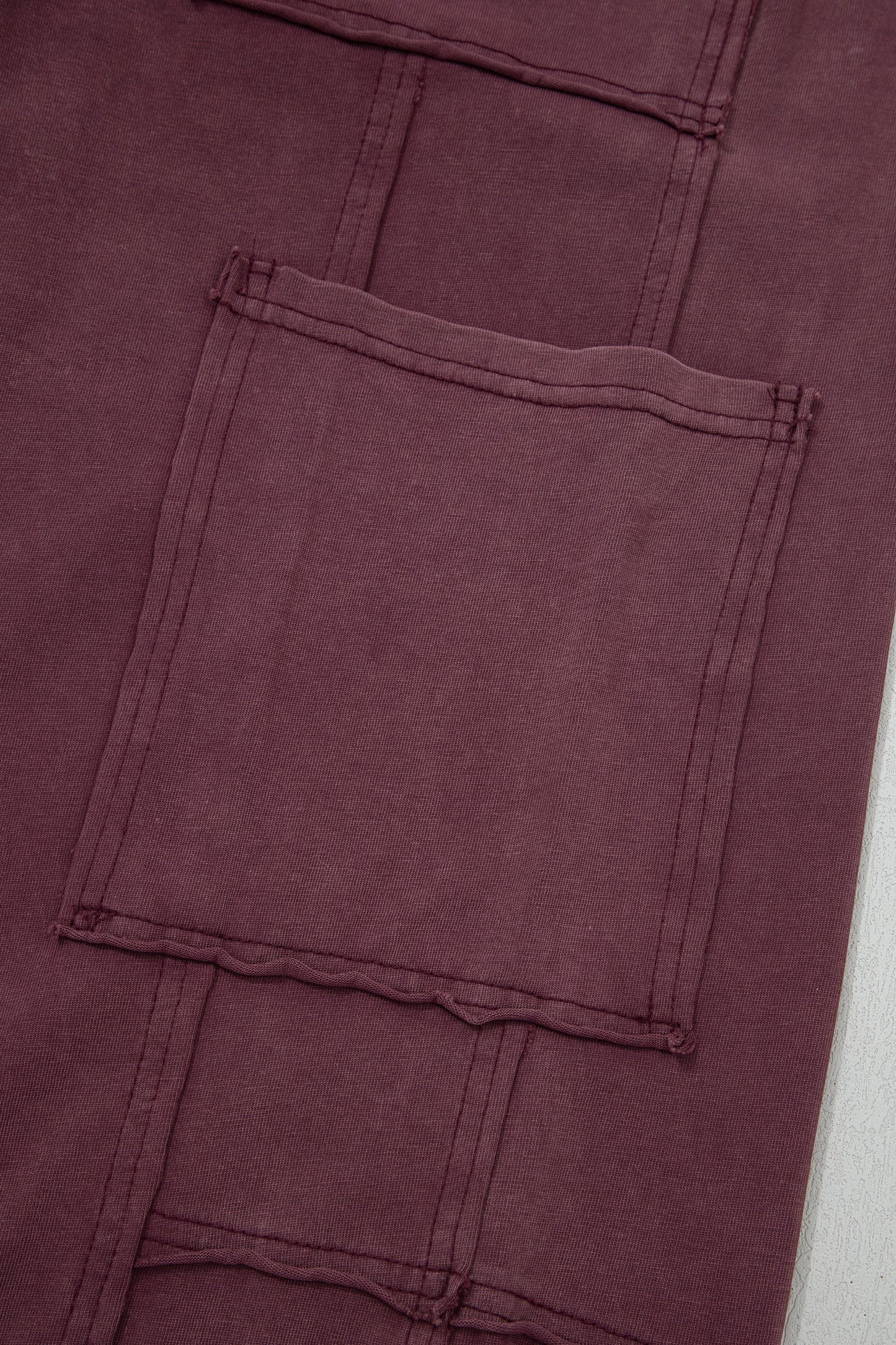 Doodlations Coffee Bar & Boutique merlot mineral wash cargo sweatpants featuring raw seam details and a large pocket.