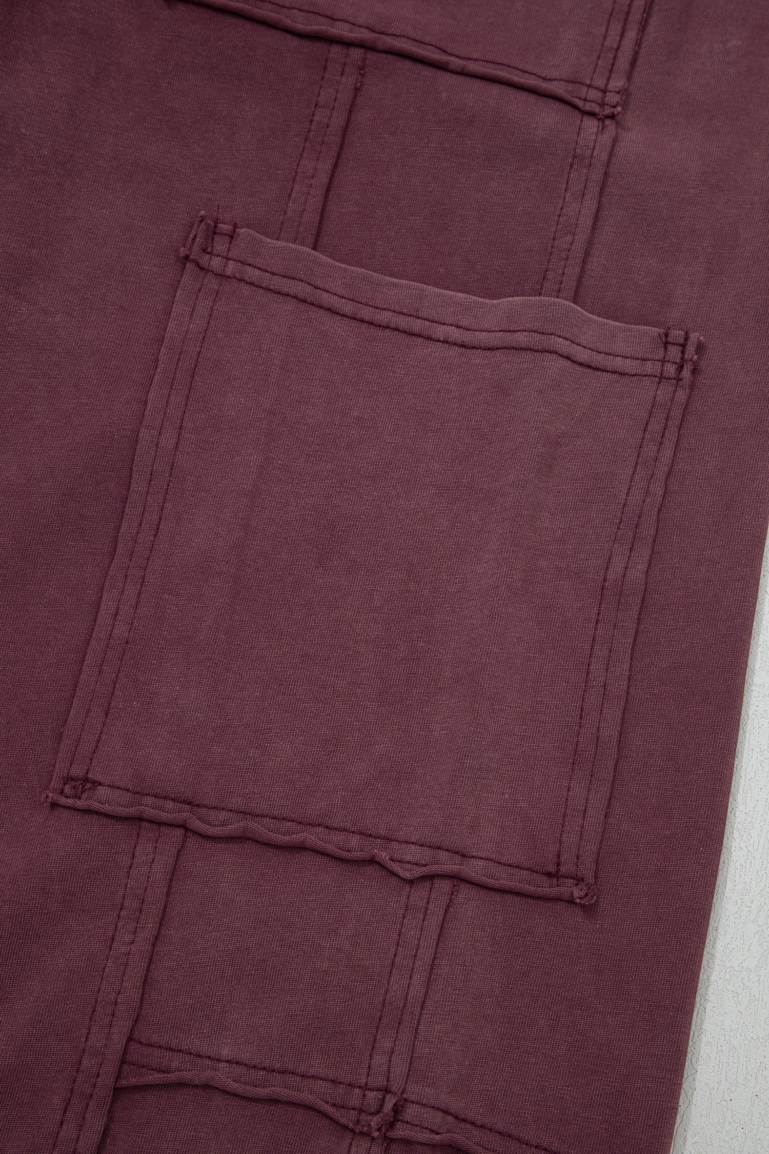 Doodlations Coffee Bar & Boutique merlot mineral wash cargo sweatpants featuring raw seam details and a large pocket.