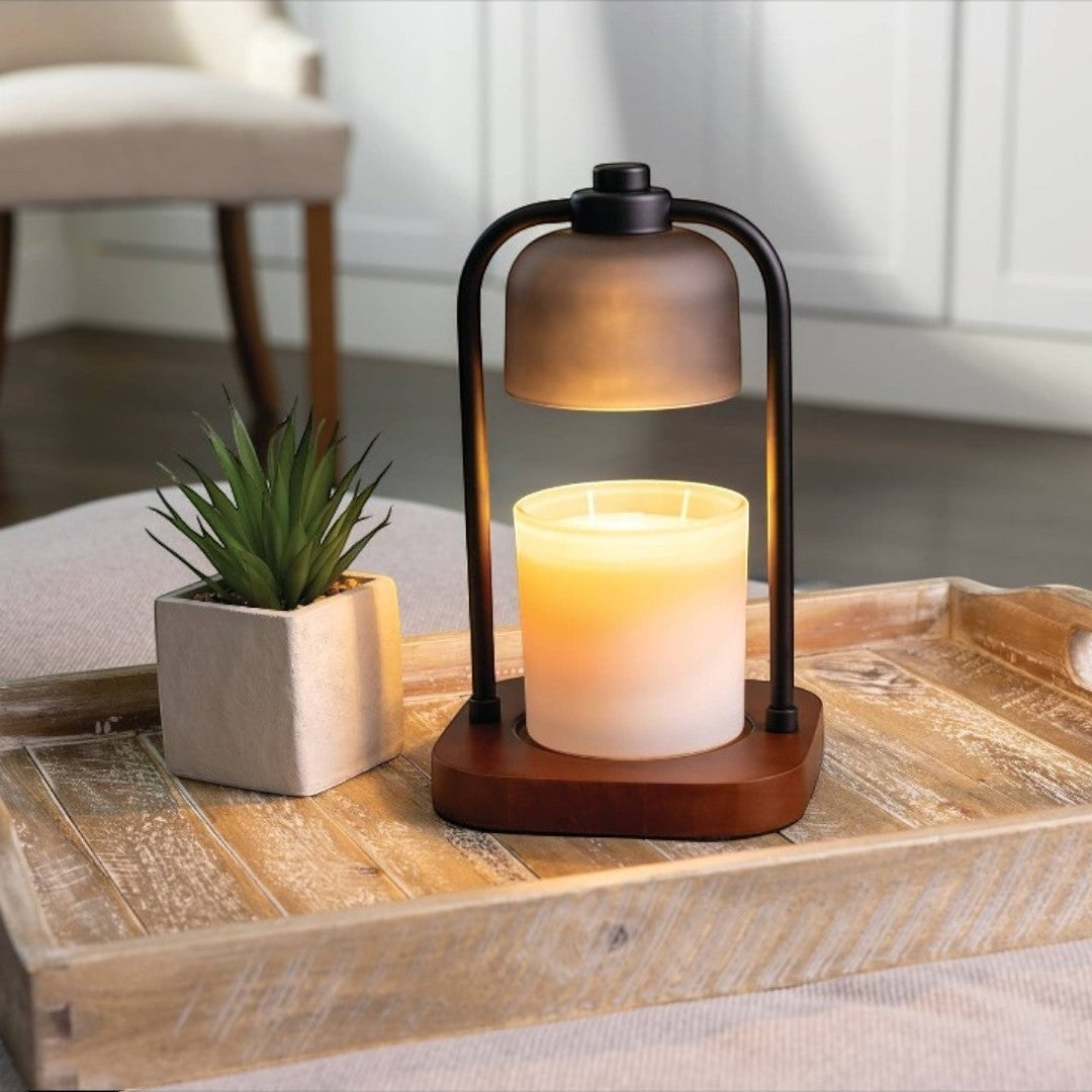 Doodlations Coffee Bar & Boutique modern candle warmer lamp with dark metal frame and wood base, gently melting a candle.
