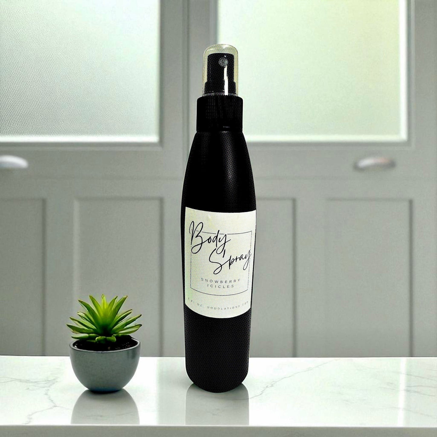 Doodlations Coffee Bar & Boutique 8oz moisturizing body spray in a black bottle with a white label on a marble table.