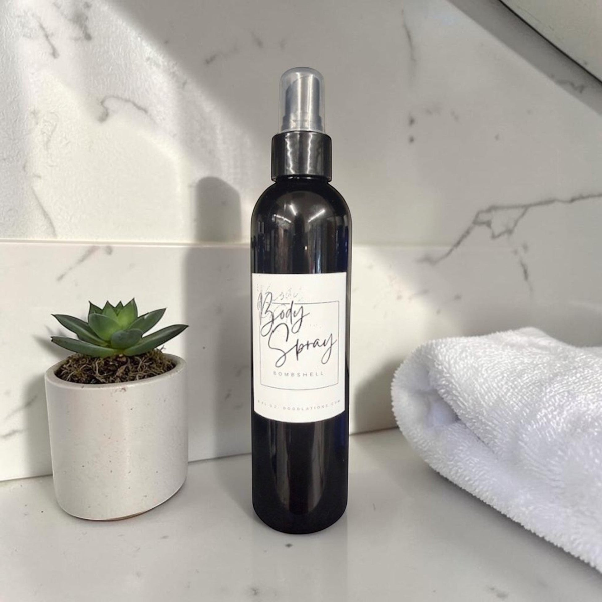 Doodlations Coffee Bar & Boutique 8oz moisturizing body spray in a black bottle with a white label on a marble counter