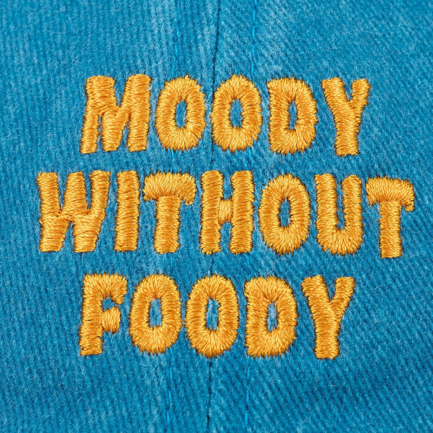 Doodlations Coffee Bar & Boutique blue cotton twill baseball cap with yellow embroidered "Moody Without Foody" text.
