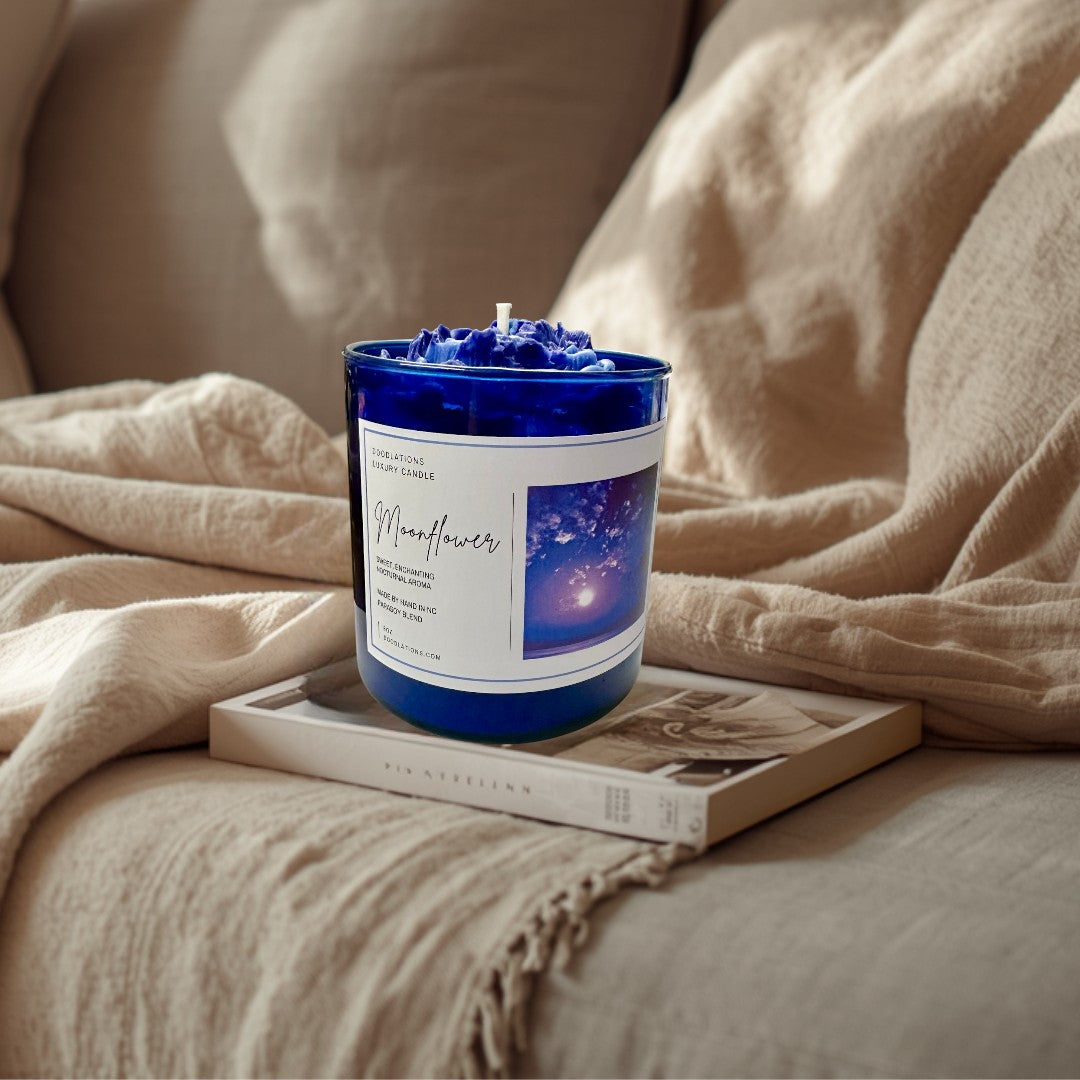 Doodlations Coffee Bar & Boutique Moonflower luxury candle in a cobalt blue jar with a wax flower topper.