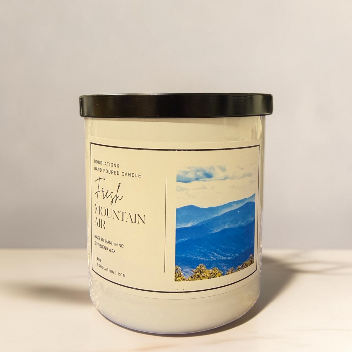 Doodlations Coffee Bar & Boutique Fresh Mountain Air soy blend luxury candle in a glass jar with a black lid